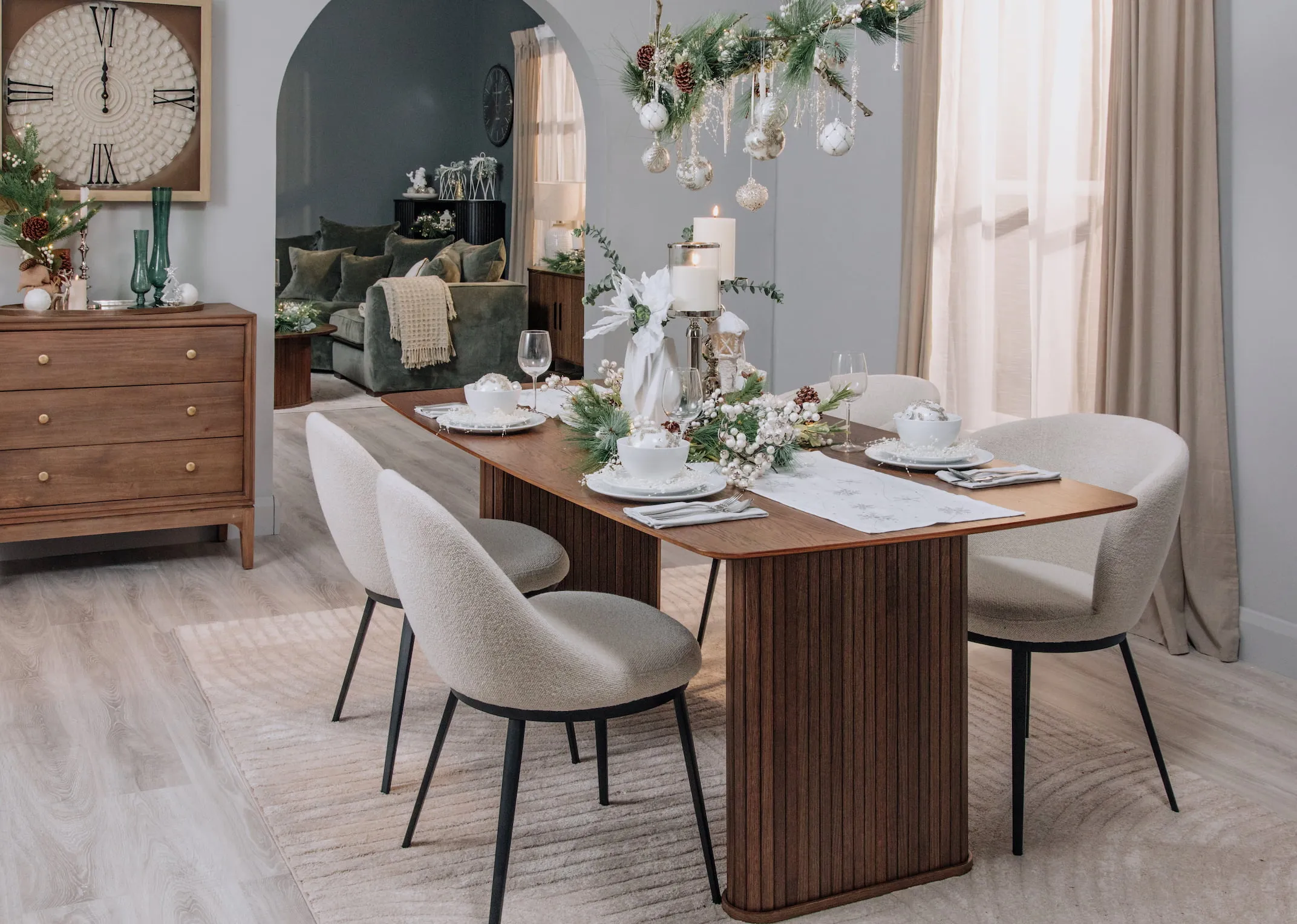 A lifestyle image of the Nola Smoked Oak dining tabel with gain dining chairs in a Christmas pearl themed styling.