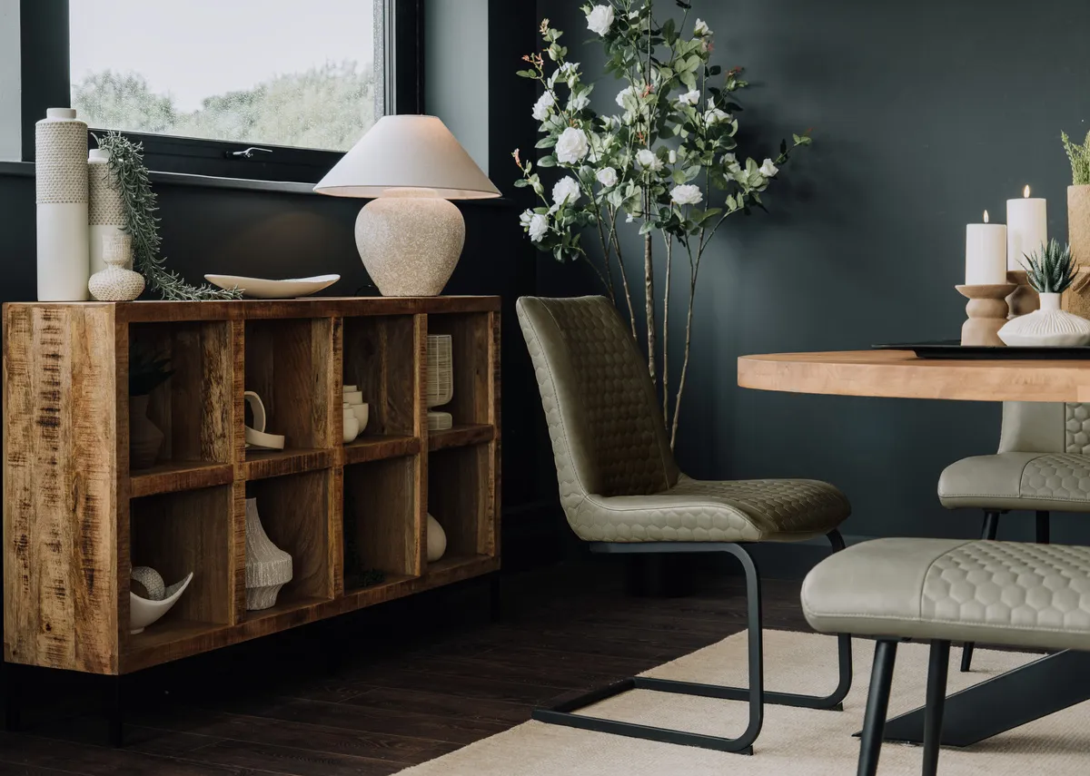 A lifestyle image of the Barton green chair with the Oslo Oval dining table and Avoca shelves