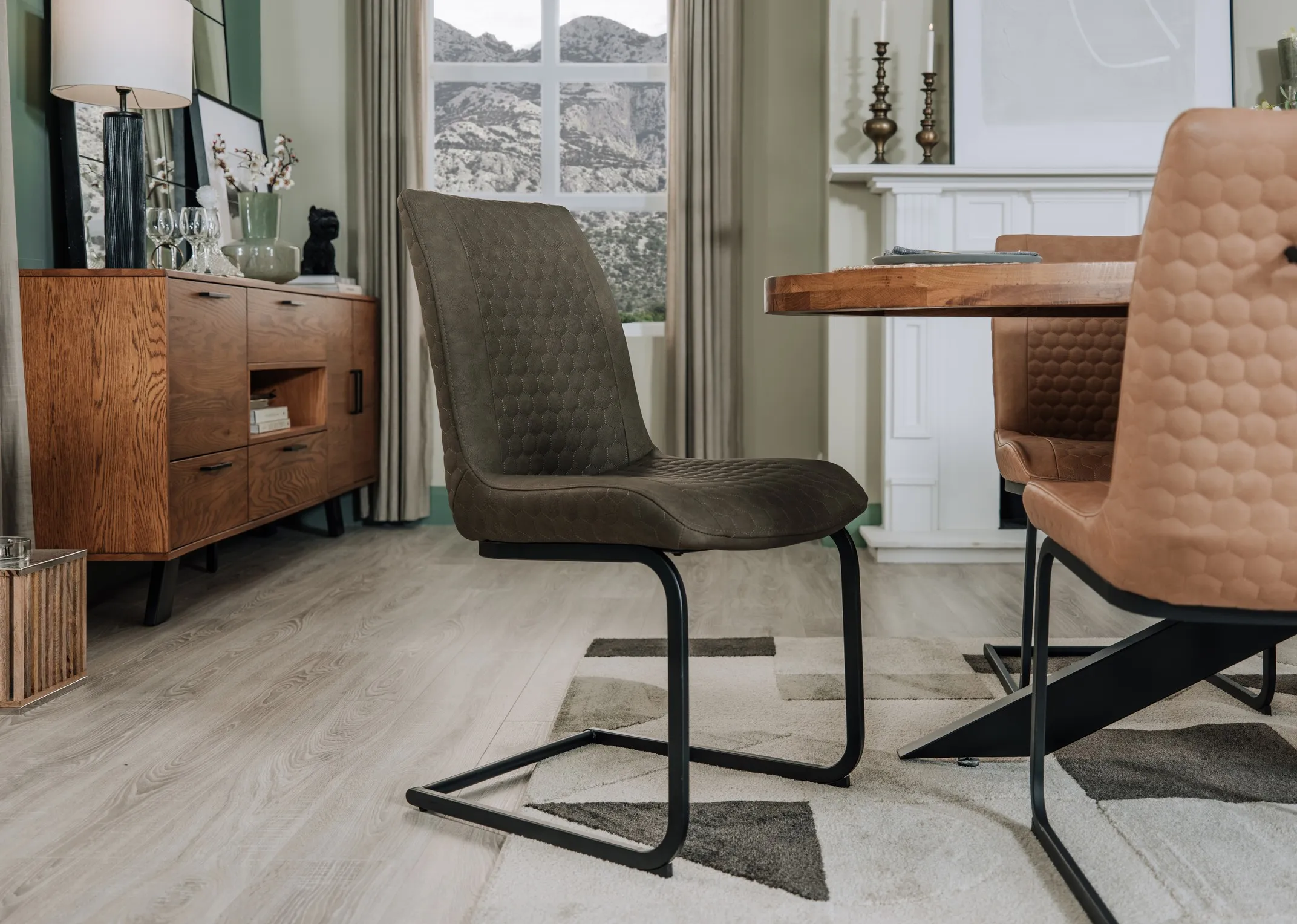 A lifestyle image of the Barton green chair with the Oslo Oval dining table and Bruni rug.