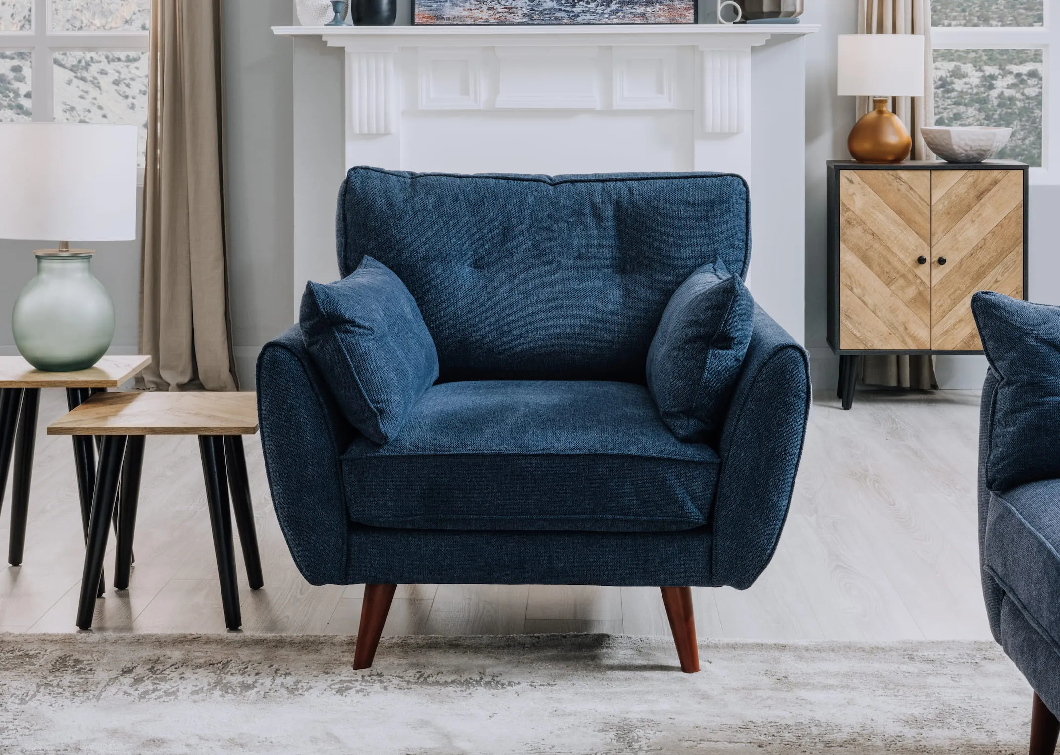 A lifestyle image of the Caoimhe navy armchair with Wicklow nest tables and Selma Table lamp.