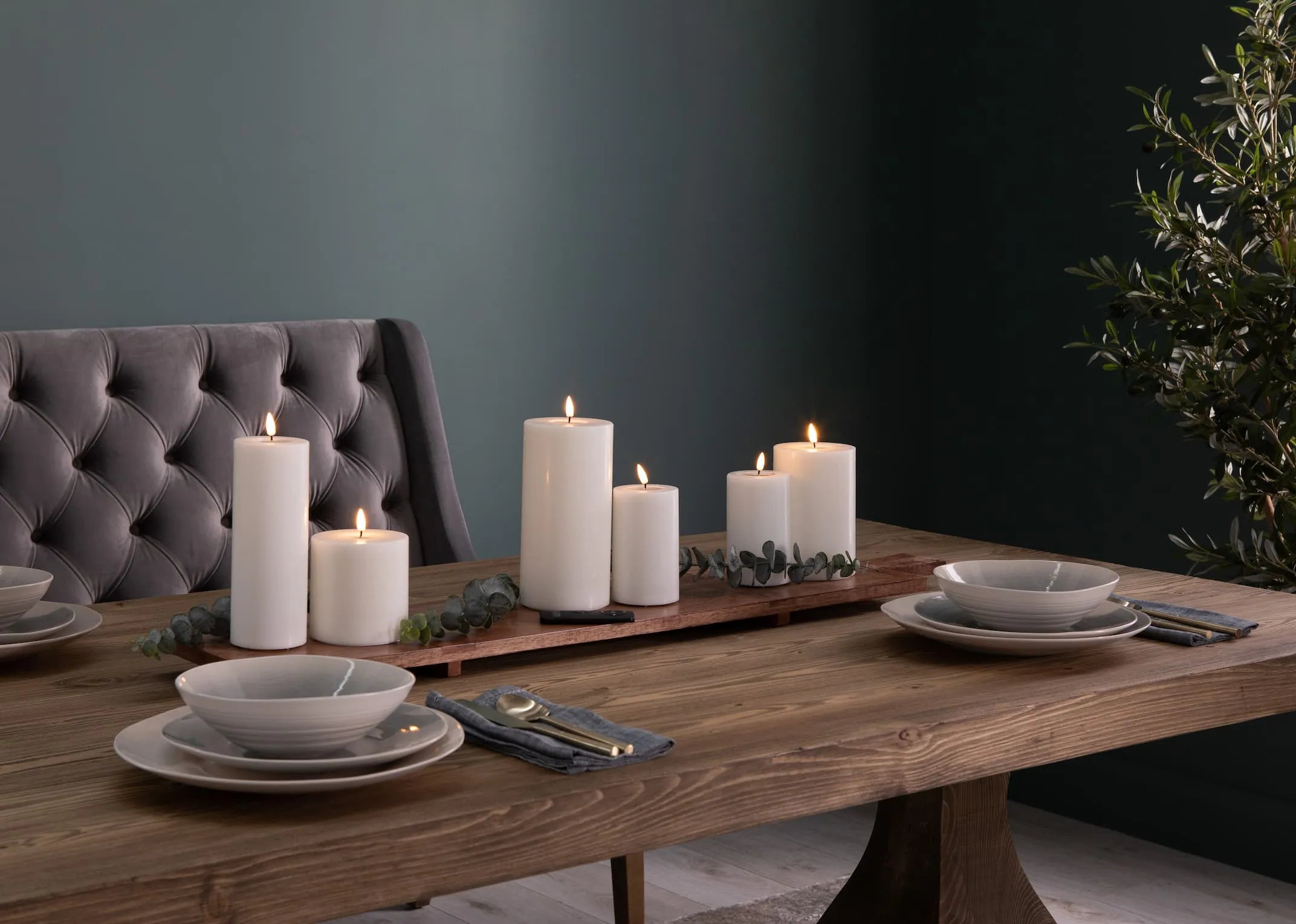 A lifestyle image of the Deluxe LED candles on a platter with greenery on the Athens dining table.