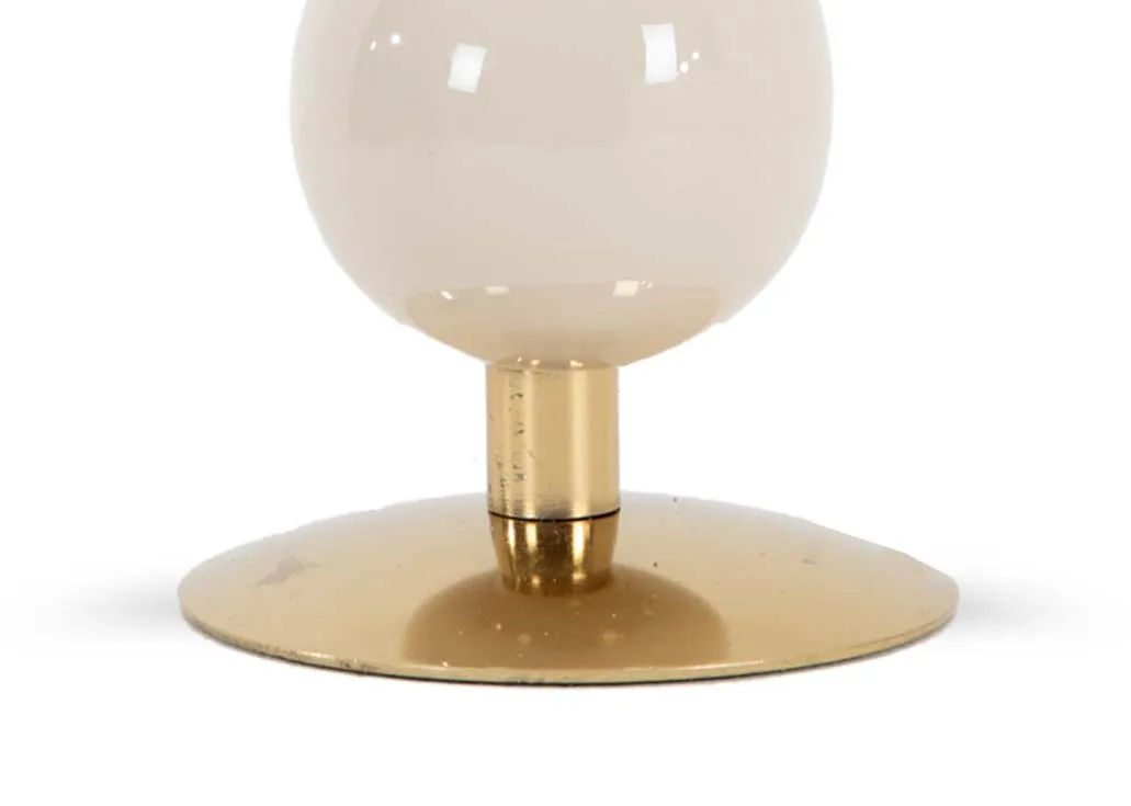 A gold candleholder base with a cream enamel round body from EZ Livings Allegra range.Closeup of round gold base.