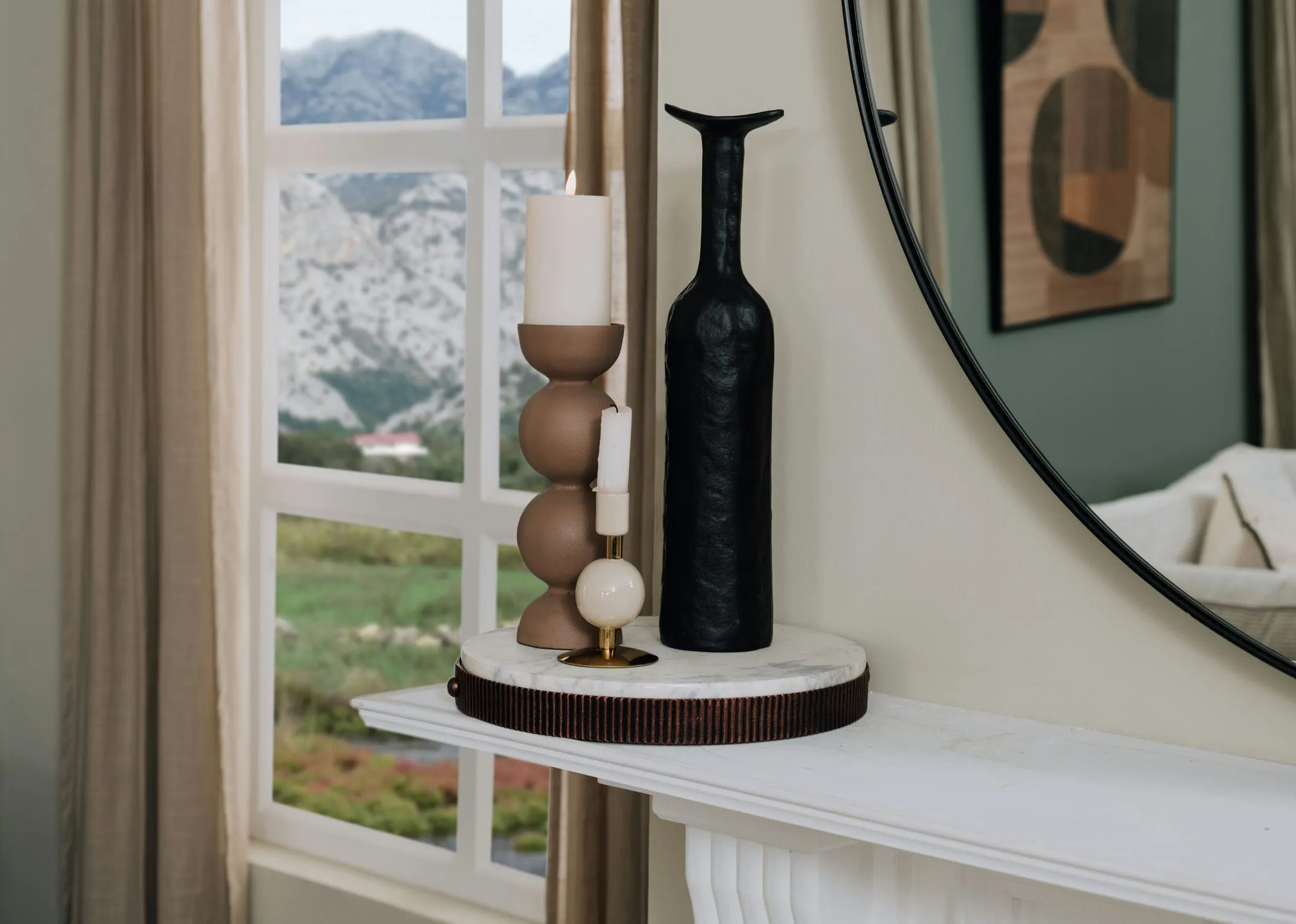 A lifestyle image of a fireplace mantle with copper tray and Allegra candle holder with Teodora vase.