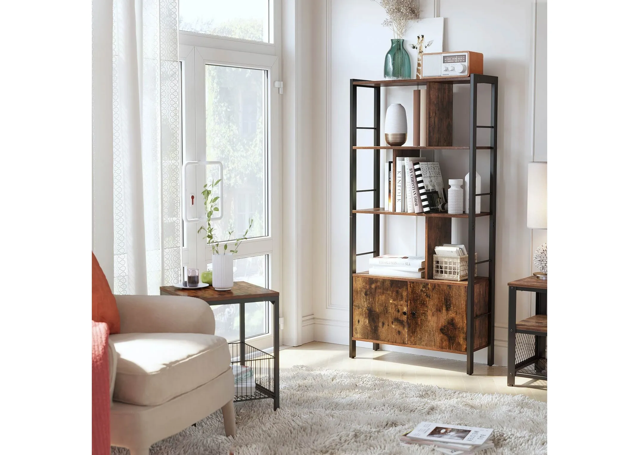 A lifestyle image of the Jools display cabinet in a bedroom with armchair and shelves dressed in plants photos and books.
