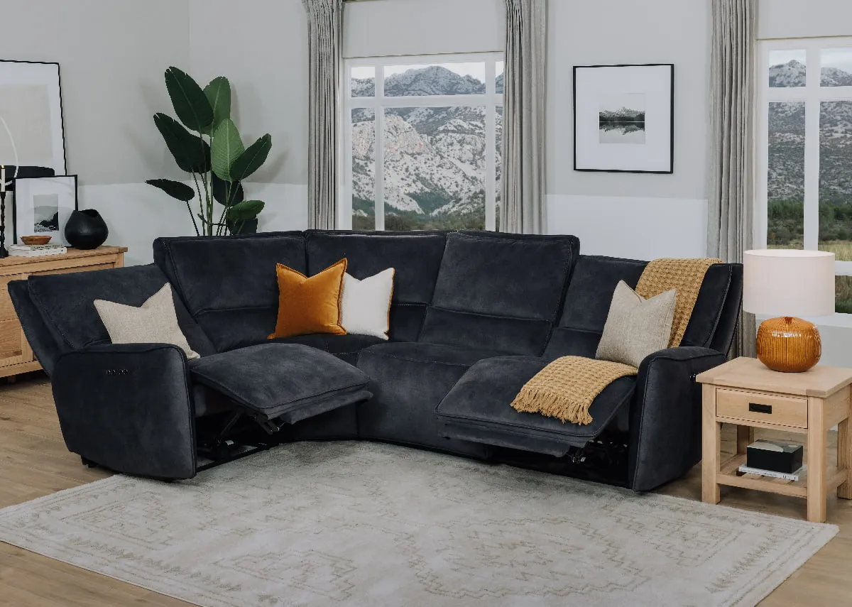 A lifestyle image of the Quentin small corner sofa with ends reclined paired with albany lamp table.