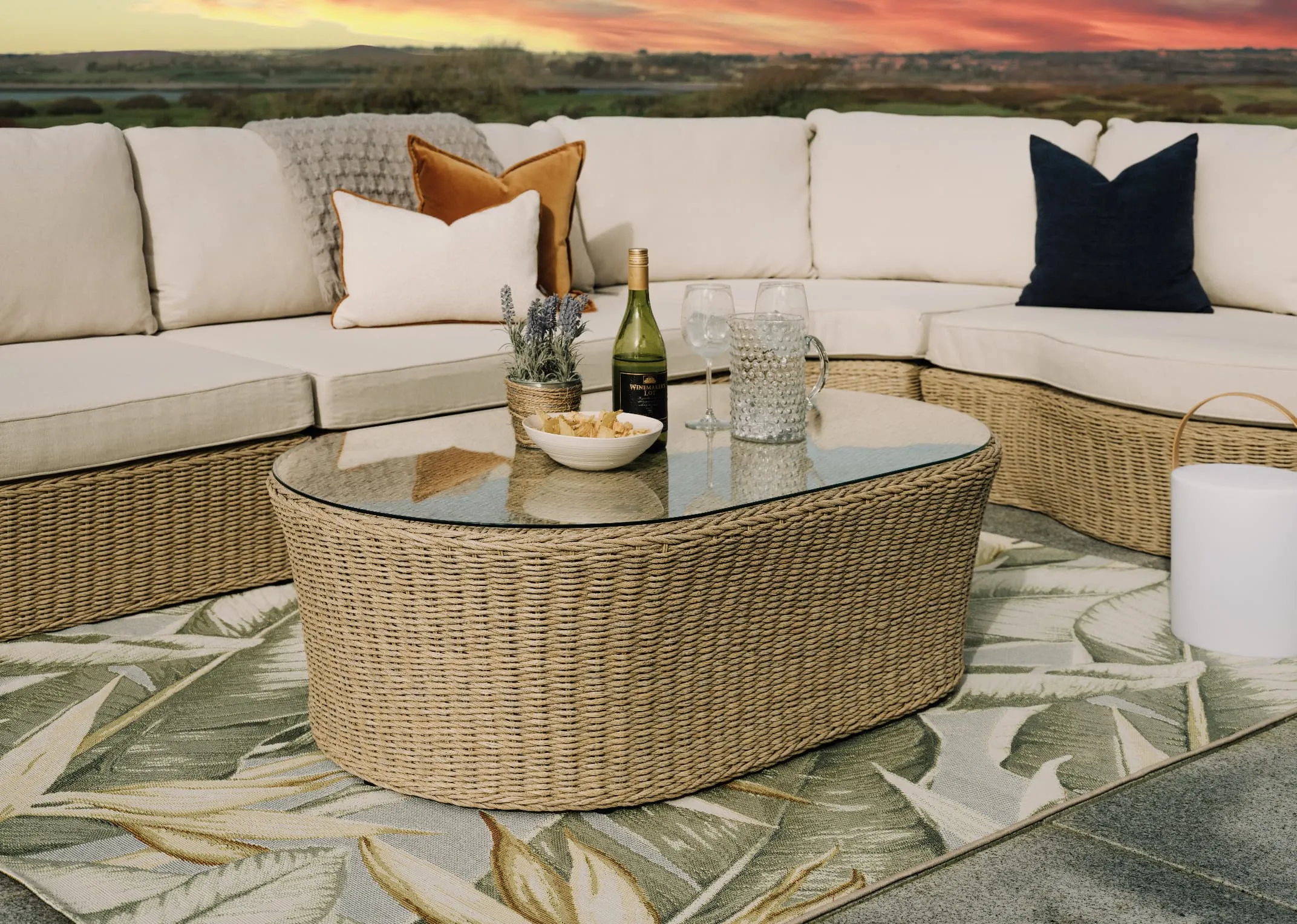 A white corner sofa with wicker base from EZ Livings Saint Tropez range. Closeup of off white fabric