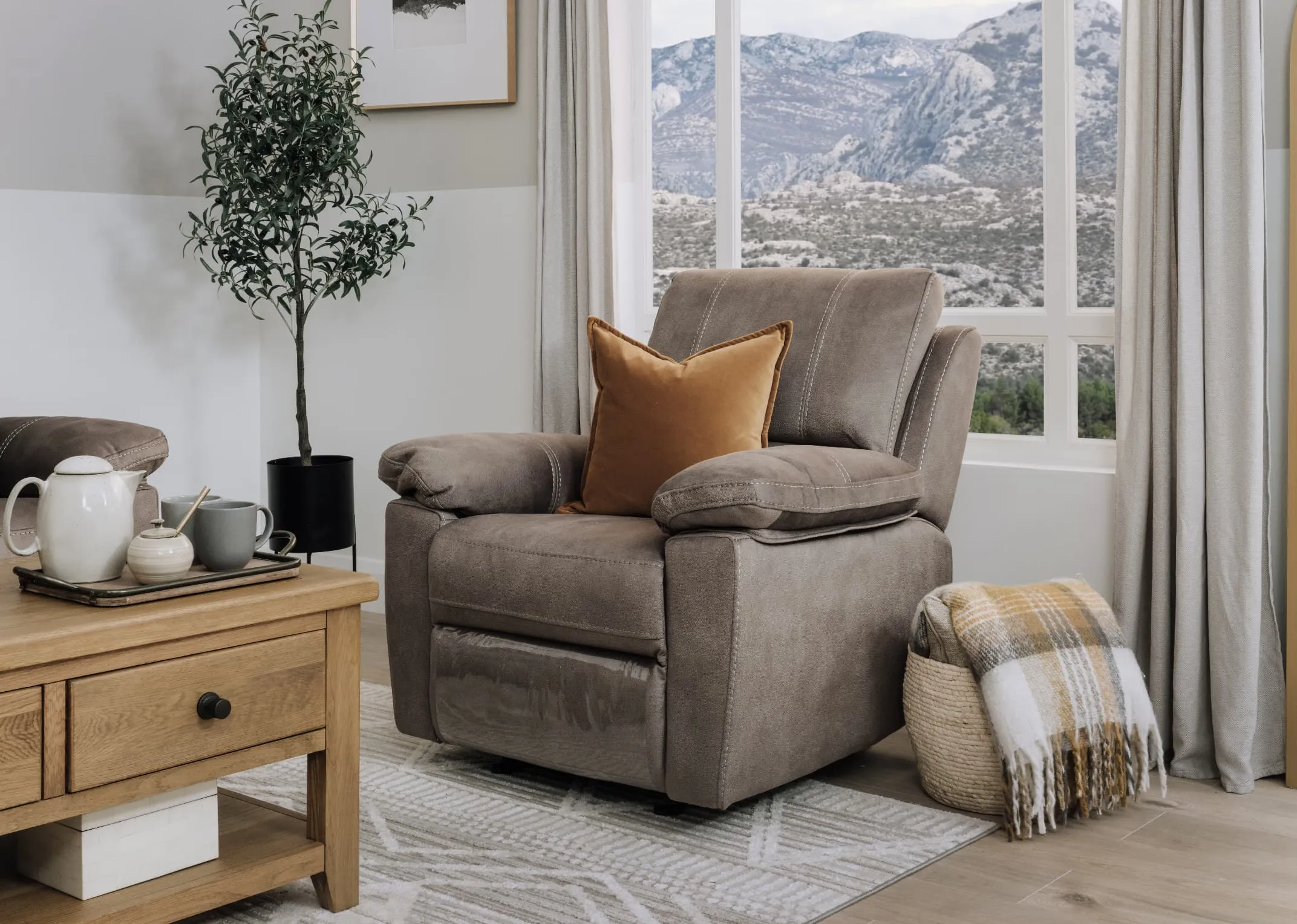 A lifestyle image of the Michigan Rocker recliner with a basket with throw beside a window with the Country Cottage coffee table.