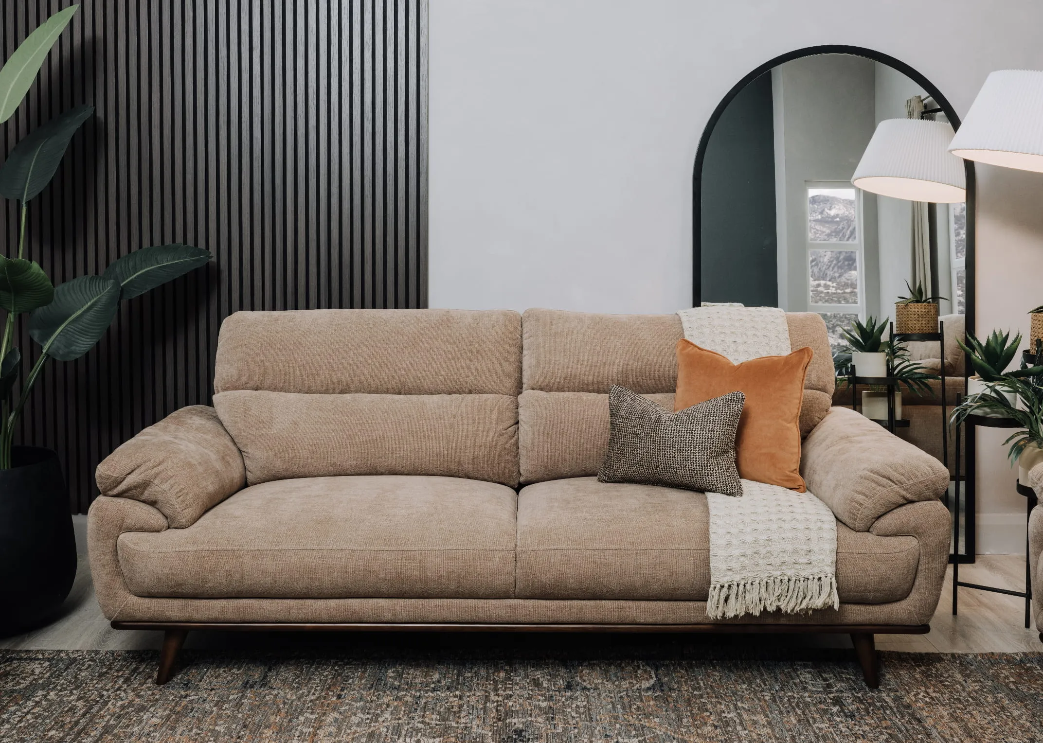 A lifetsyle image of the Pippa 3 seater with cushions and waffle throw with Chrisley mirror.