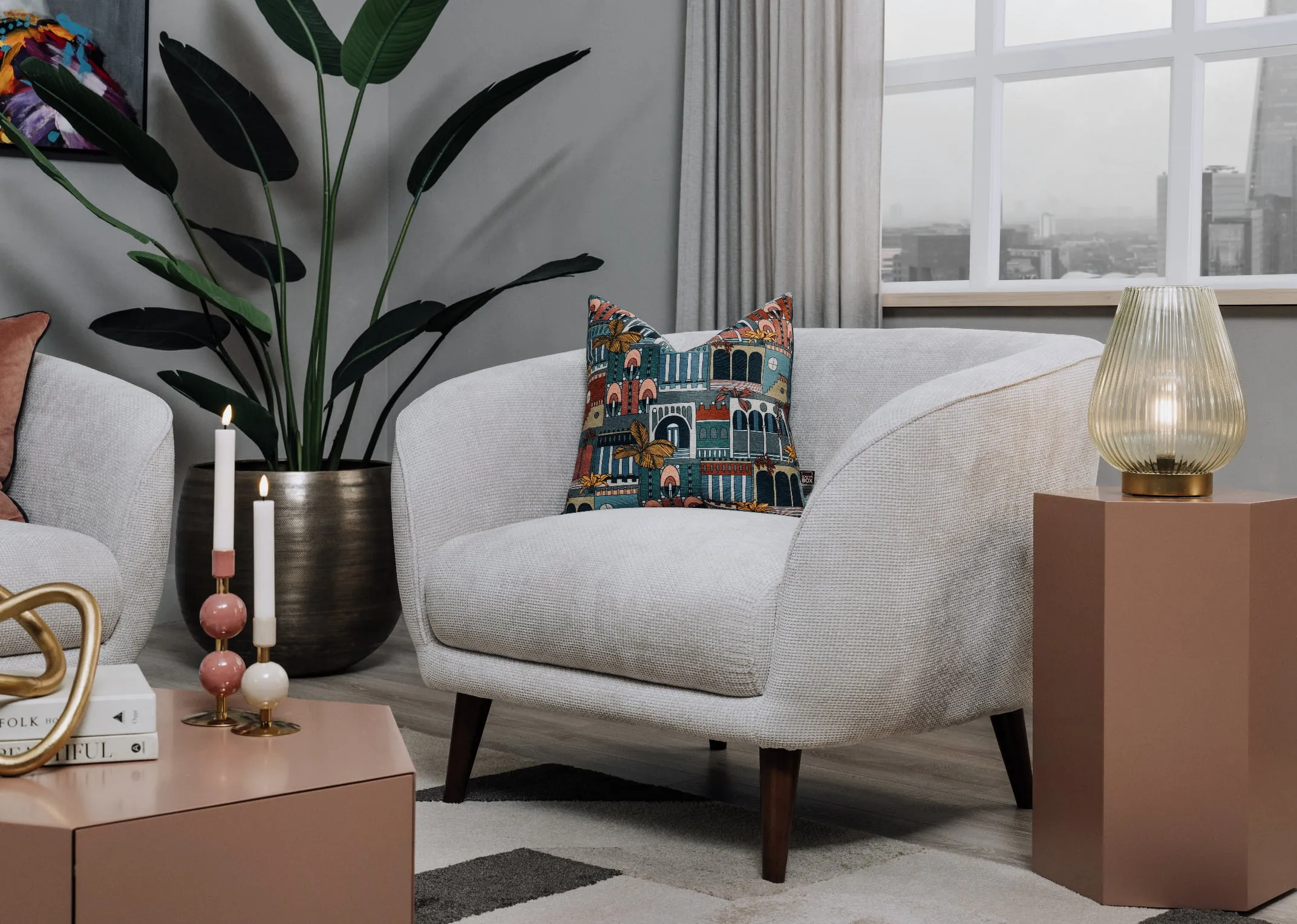 A lifestyle image of the Amber armchair with Jonas tables and table lamp.