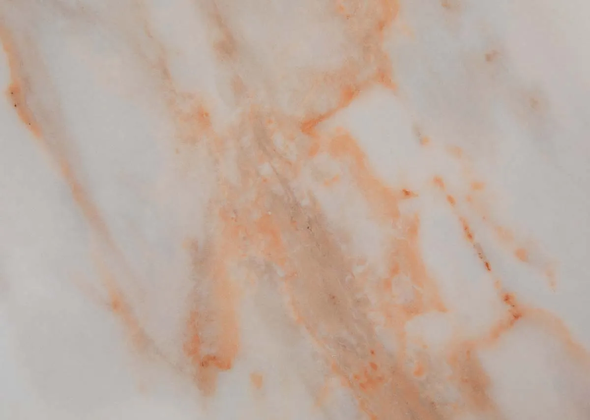 A round melamine top dining table with oak legs from EZ Livings Ravello range. Closeup of marble finish.