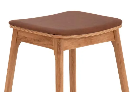 An oak bar stool with tan faux leather seat from EZ Livings Ravello range. Closeup of tan curved seat