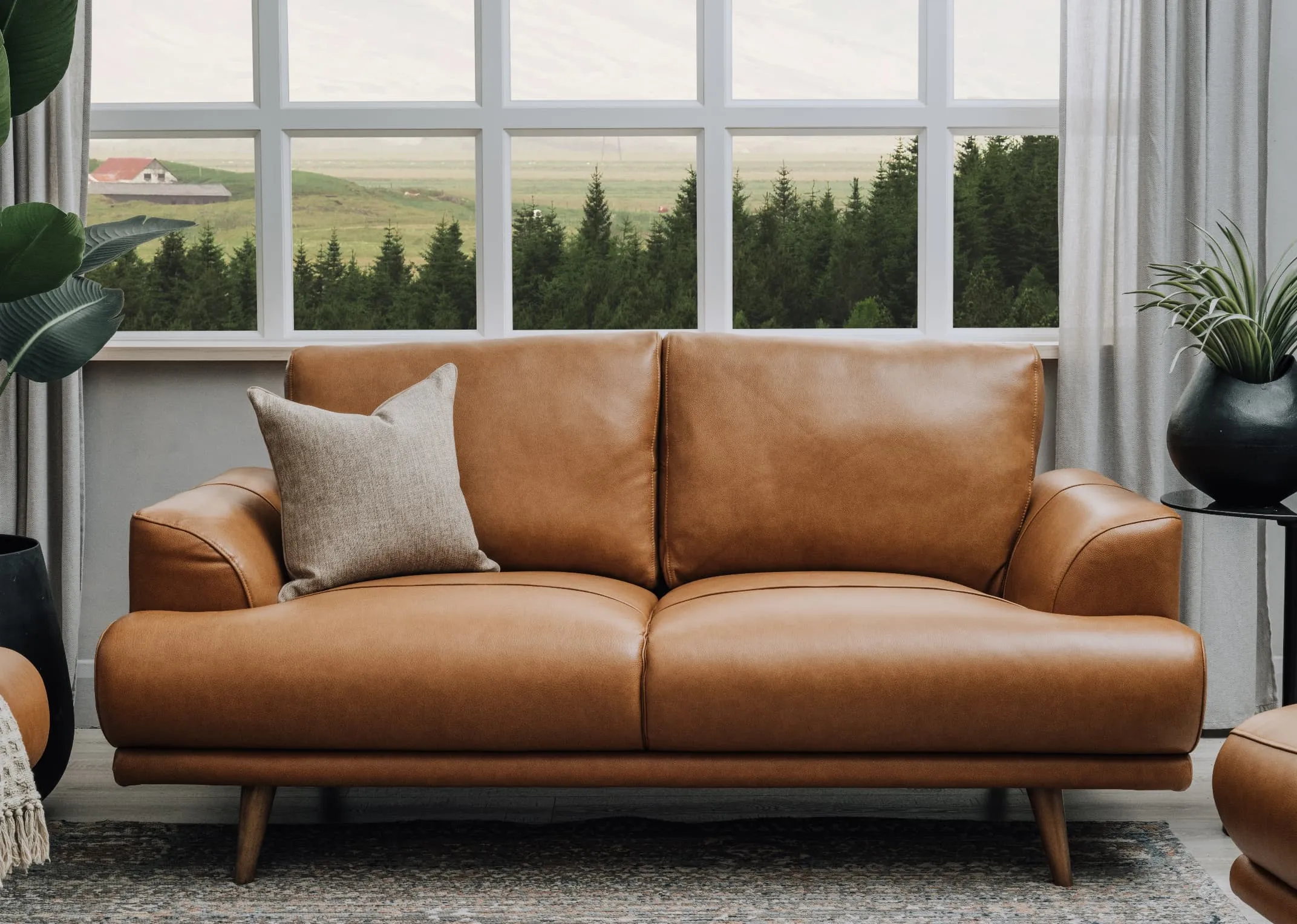 A lifestyle image of the Legend 2 Seater with cushion and Maxima rug.