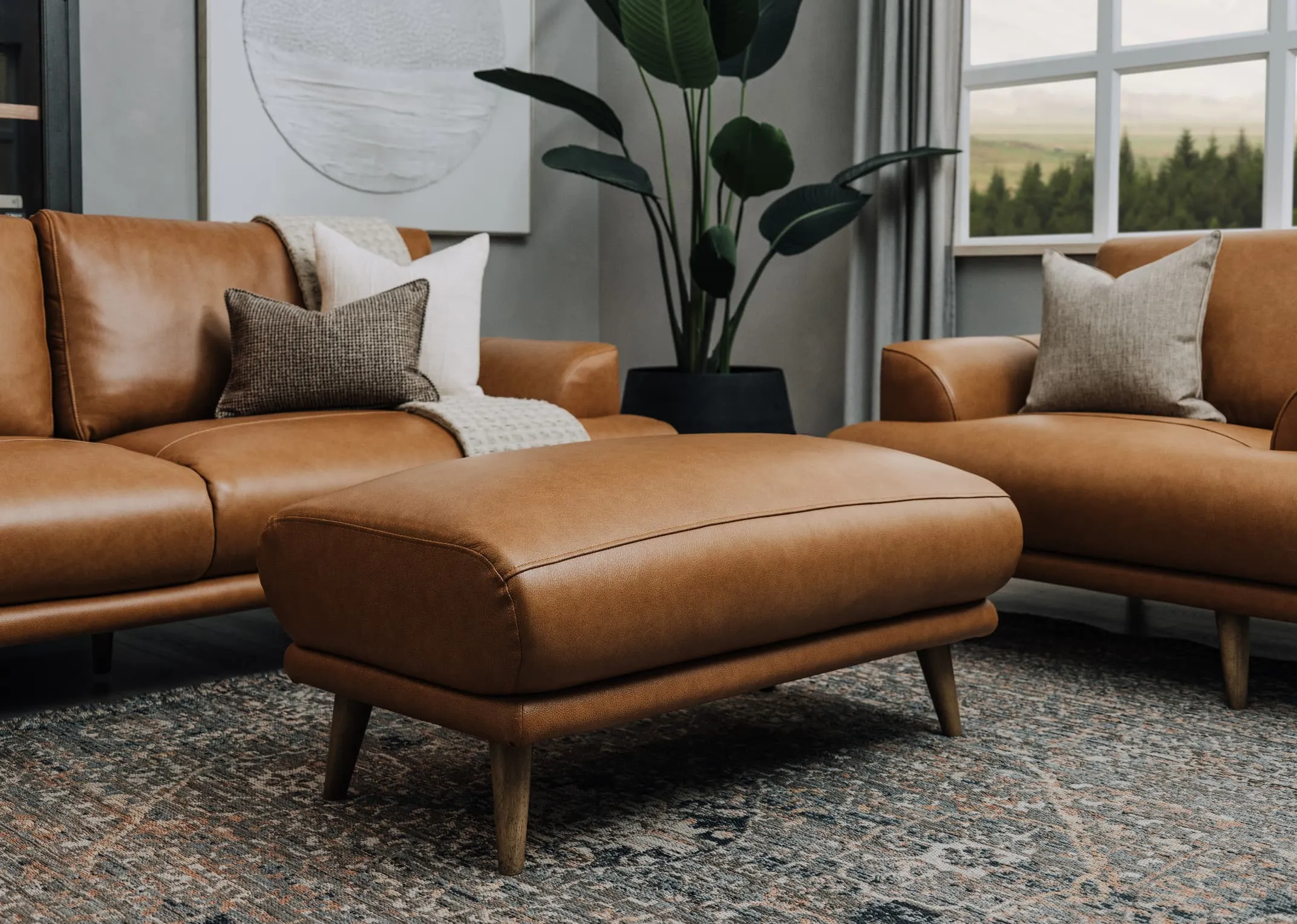 A lifestyle image of the Legend Footstool with Maxima rug and the matching Leather sofas.