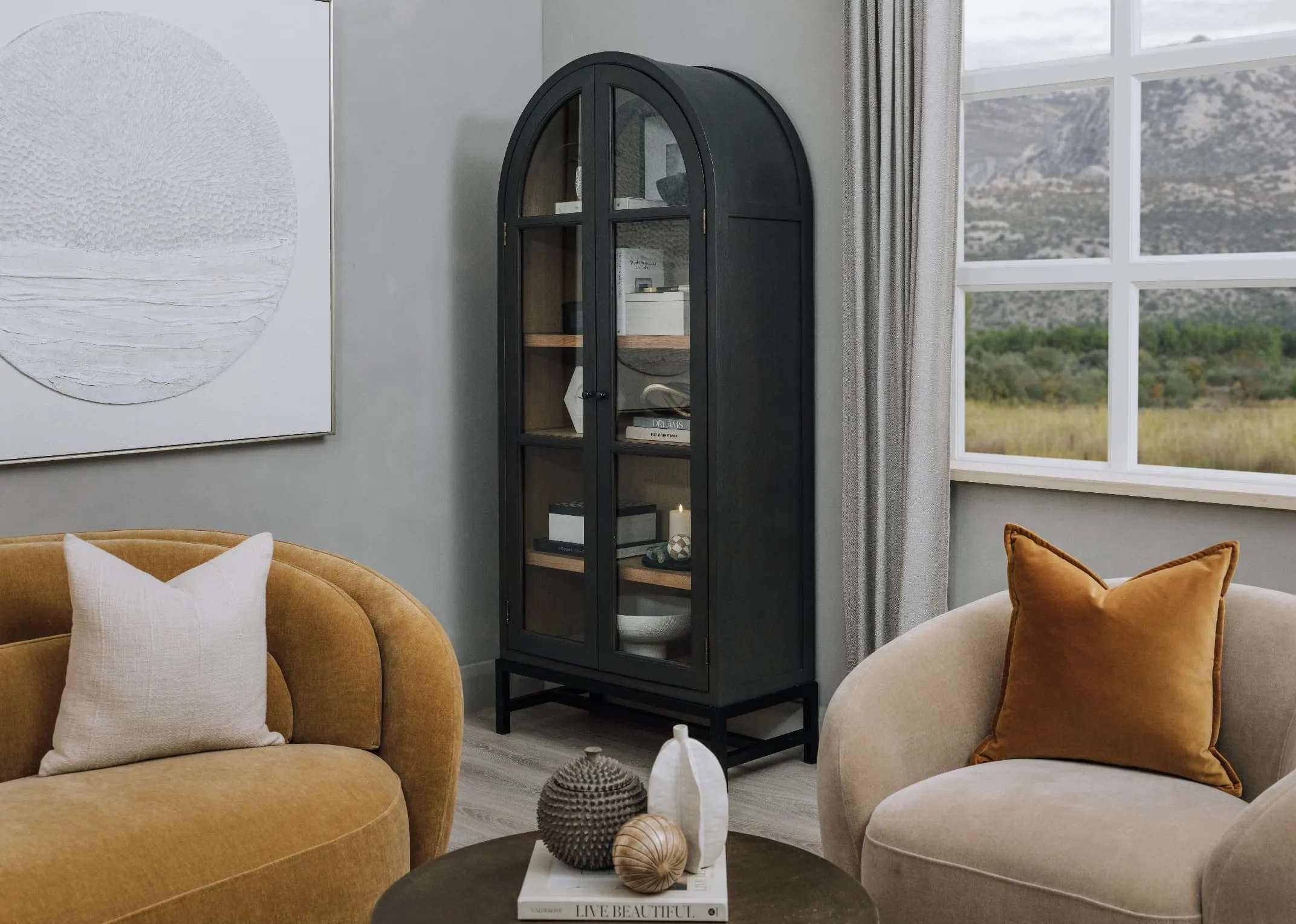 A lifestyle image of the Juliet Cabinet with doors open with lots of accessories including books