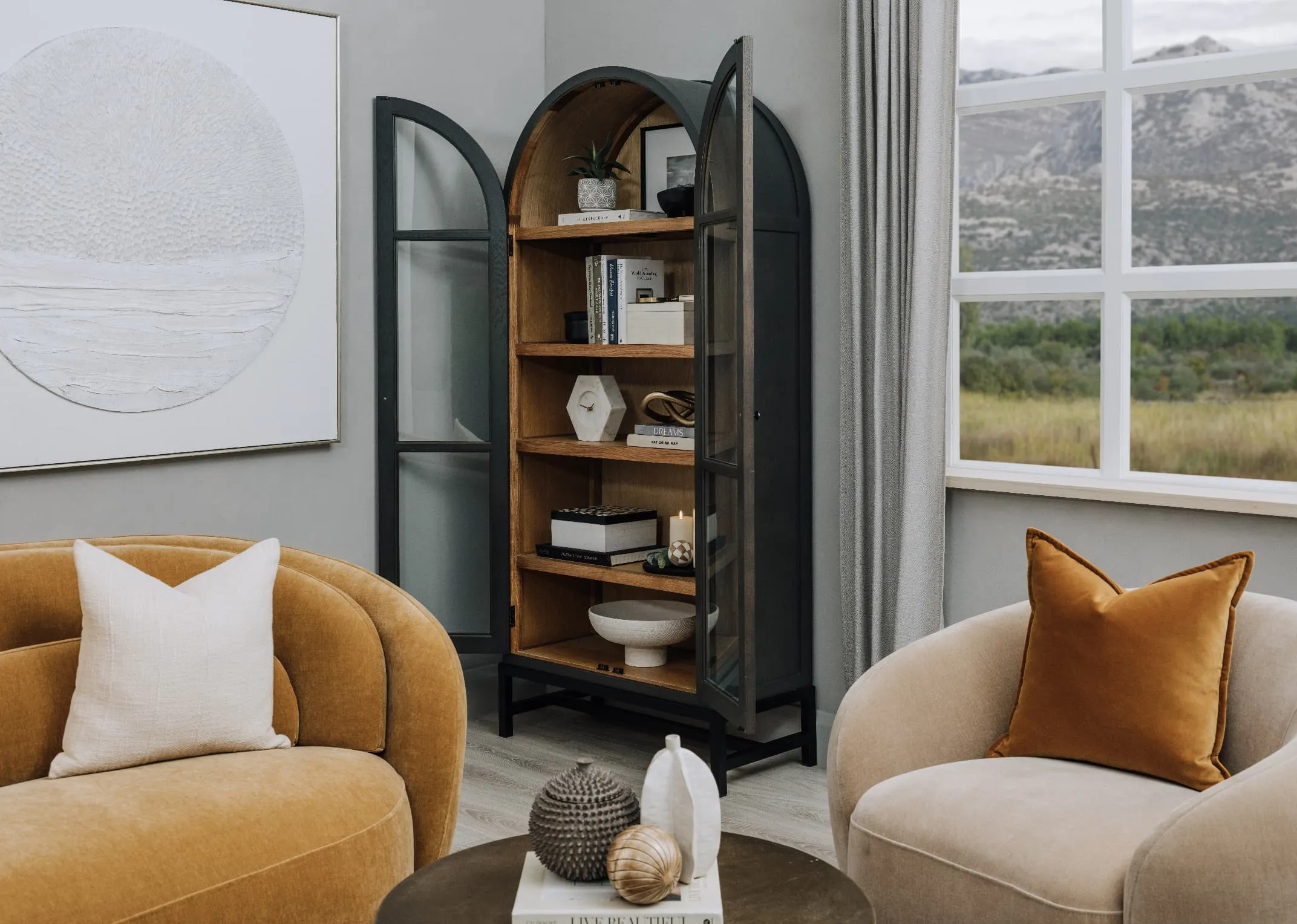 A lifestyle image of the Juliet Cabinet with doors open with lots of accessories including books