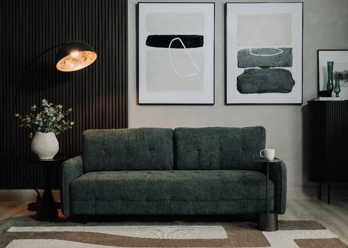 A lifestyle image of the Merrion sofabed as a sofa with cushions and Elite floor lamp with Mode & Intense canvas pics.