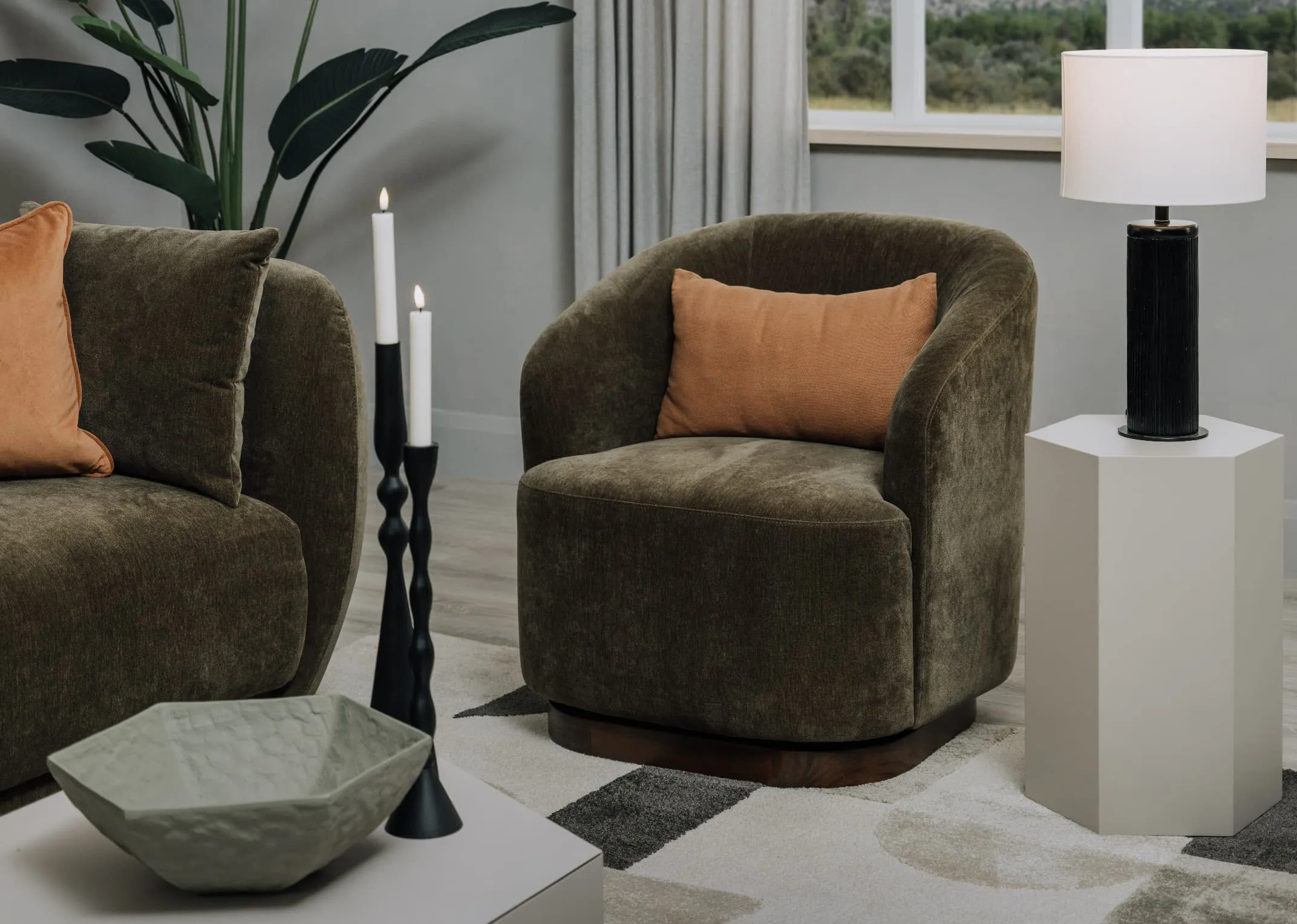 A lifestyle image of the Derby Swivel Chair with Jonas side table with Lohas table lamp.