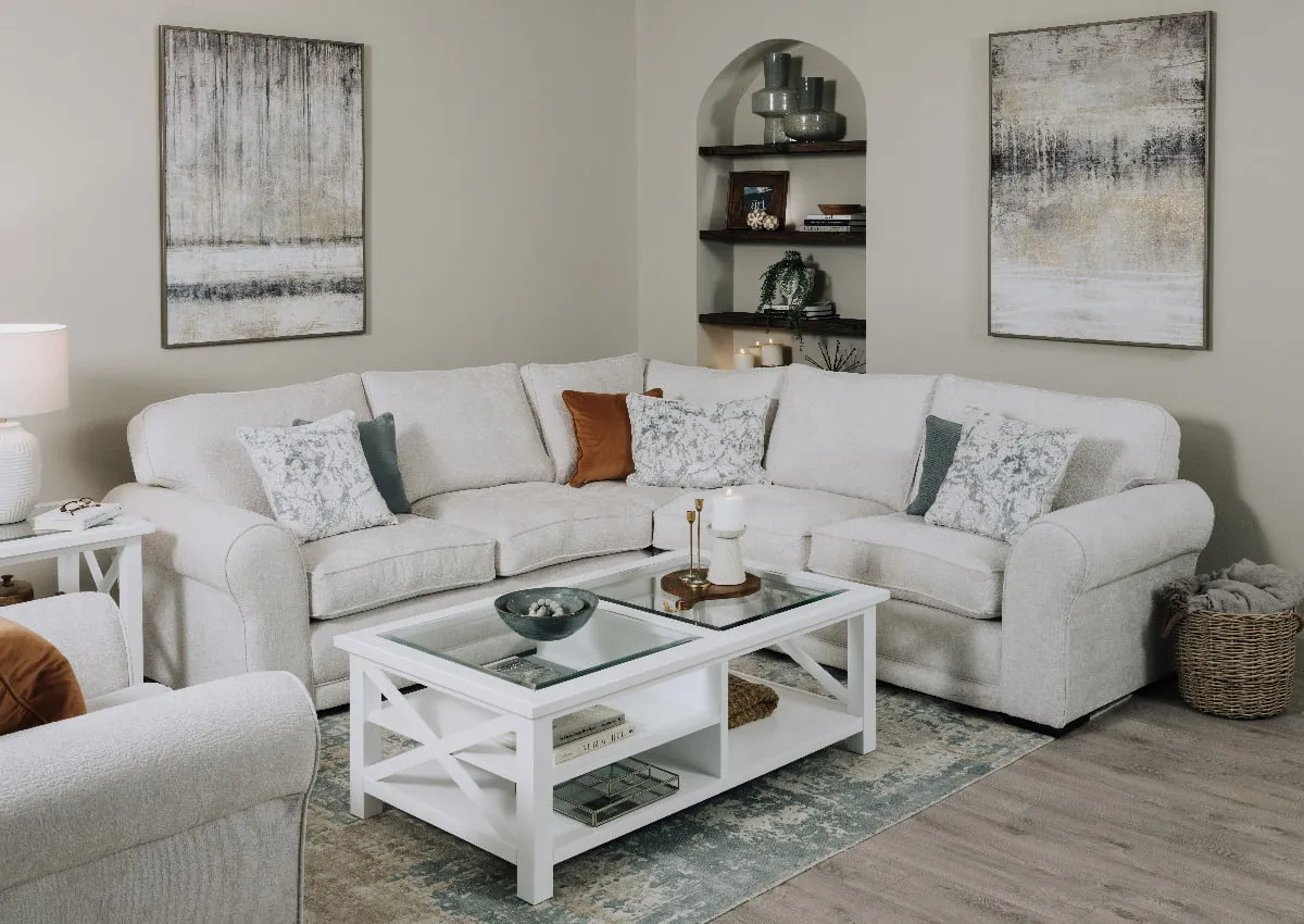 A lifestyle image of the Kenmare Corner sofa and armchair with Hampton coffee table and Torrent canvas prints