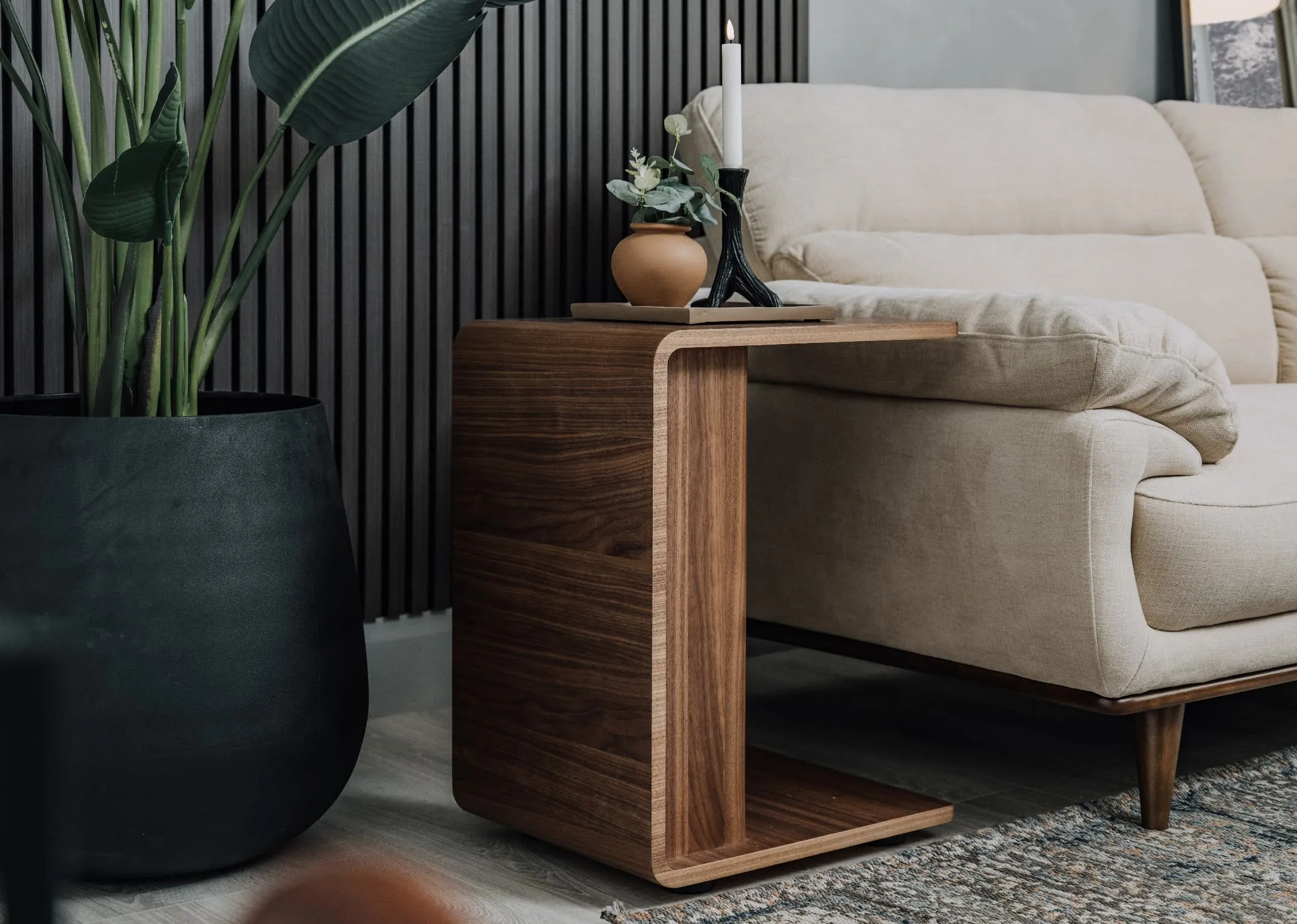 A lifestyle image of the Uptoen side table over the armrest of the Pippa cream sofa range.