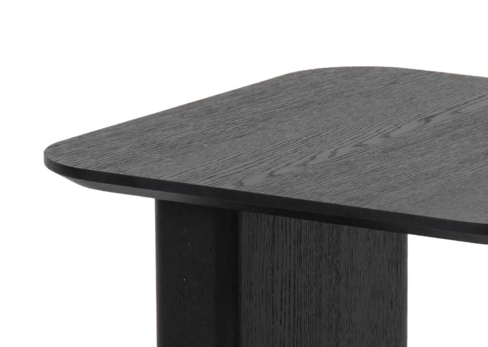 A black oak lamp table with one gold painted leg from EZ Livings Echo range. Closeup of wood finish.