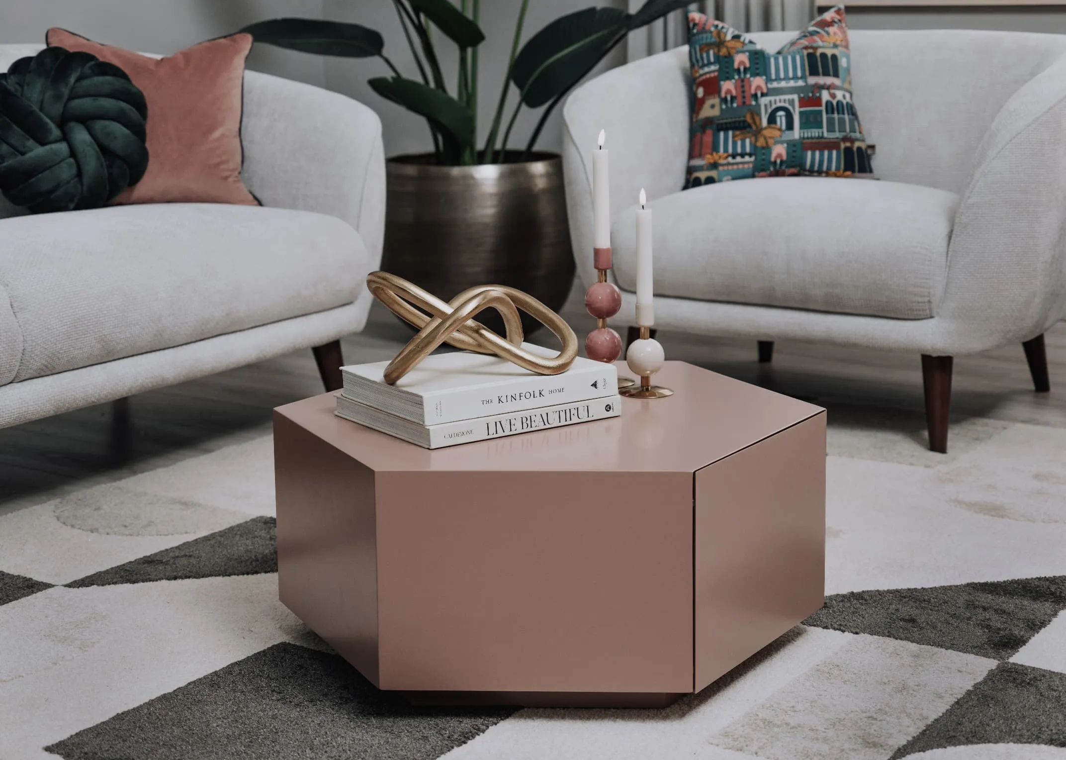A lifestyle image of the Jonas coffee table with drawer closed & candle holders on top with Amber armchair.