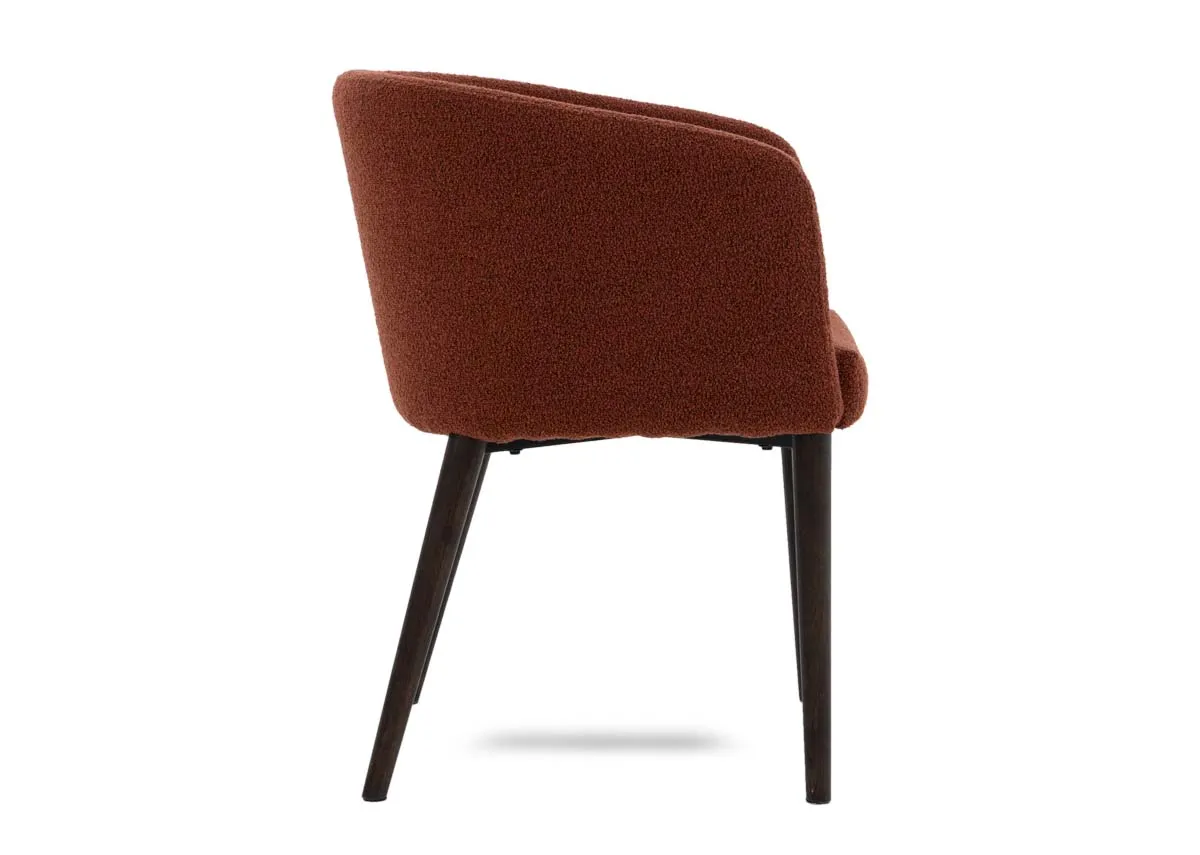 A curved orange dining chair from EZ Livings Bardot range. Side view of curved arms and angled metal legs