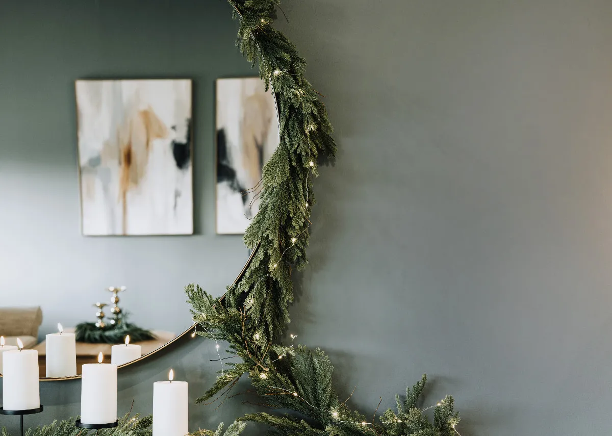A dimension image of the Pine needle garland around the elling mirror with candle holders