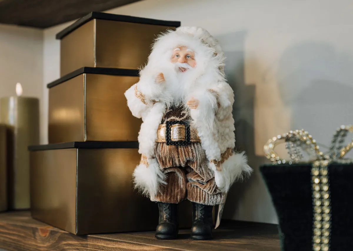 A lifestyle image of the Santa Claus figurine with a set of 3  gold  boxes