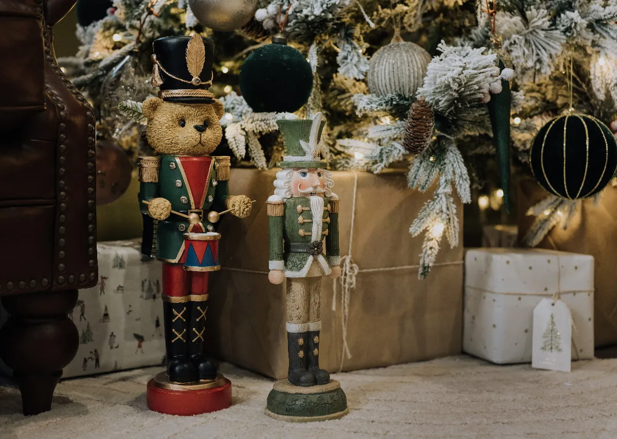 A lifetsyle image of the Teddy Nutcracker with drum and King John Nutcracker under a tree