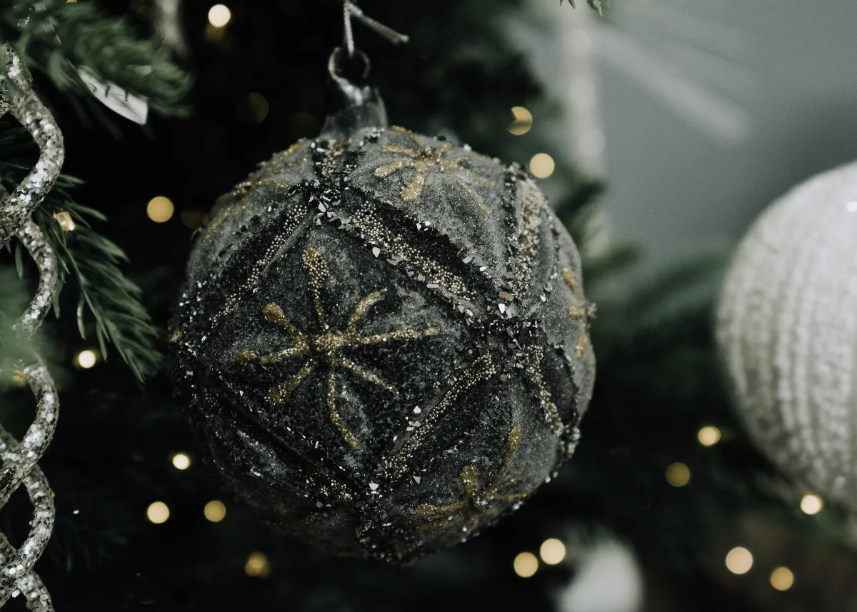 A lifetsyle image of the First Noel bauble on a lit Christmas tree