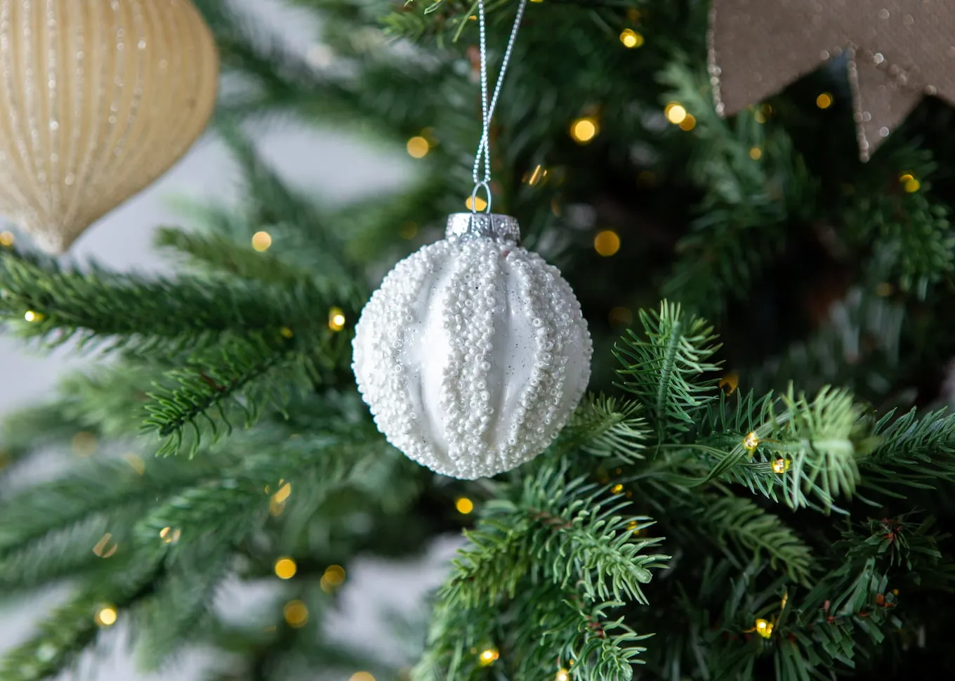A lifebstyle image of This Little Light bauble set on a christmas tree.