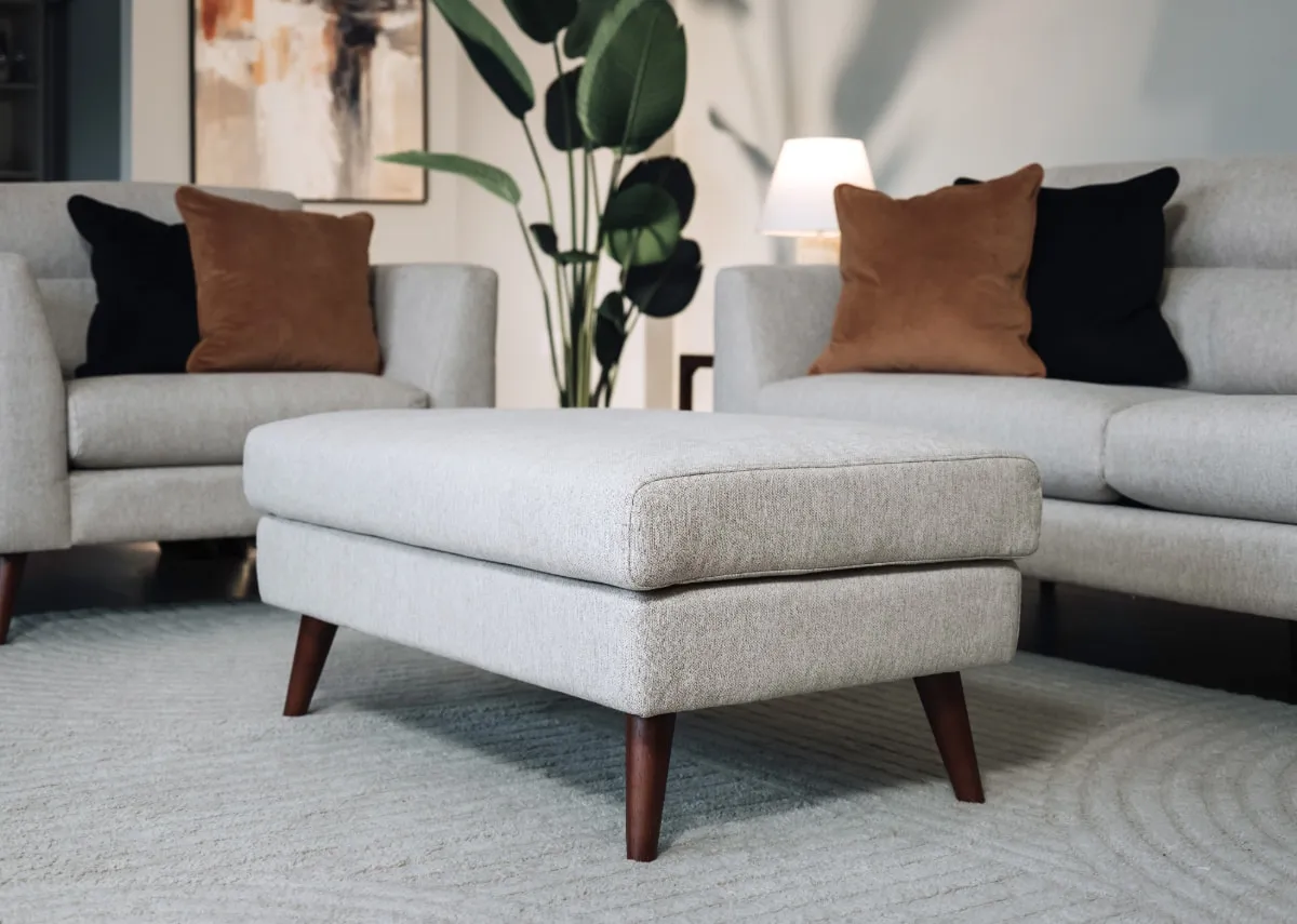A lifestyle image of the Presley large footstool with elio rug from EZ Living Furniture.