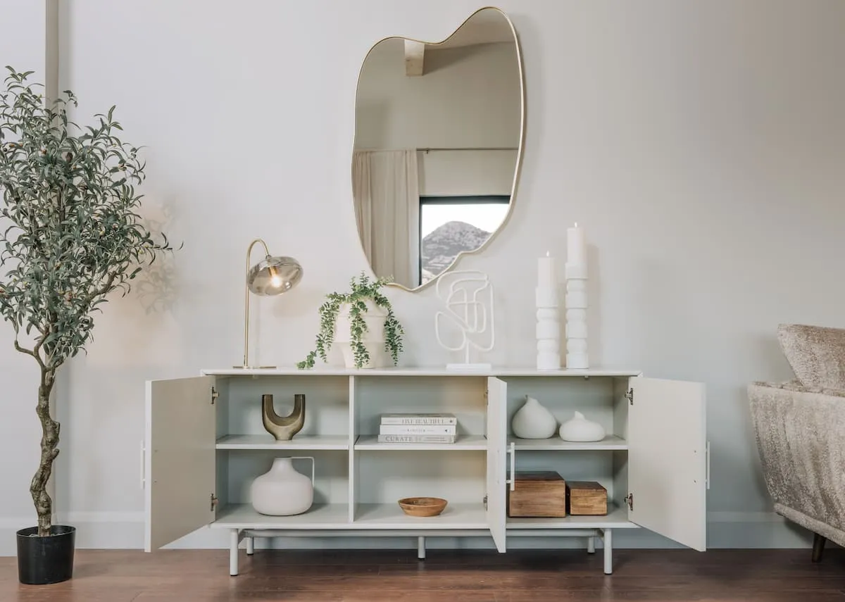 A lifestyle image of the Palma White Sideboard with Benton mirror and lekar table lamp