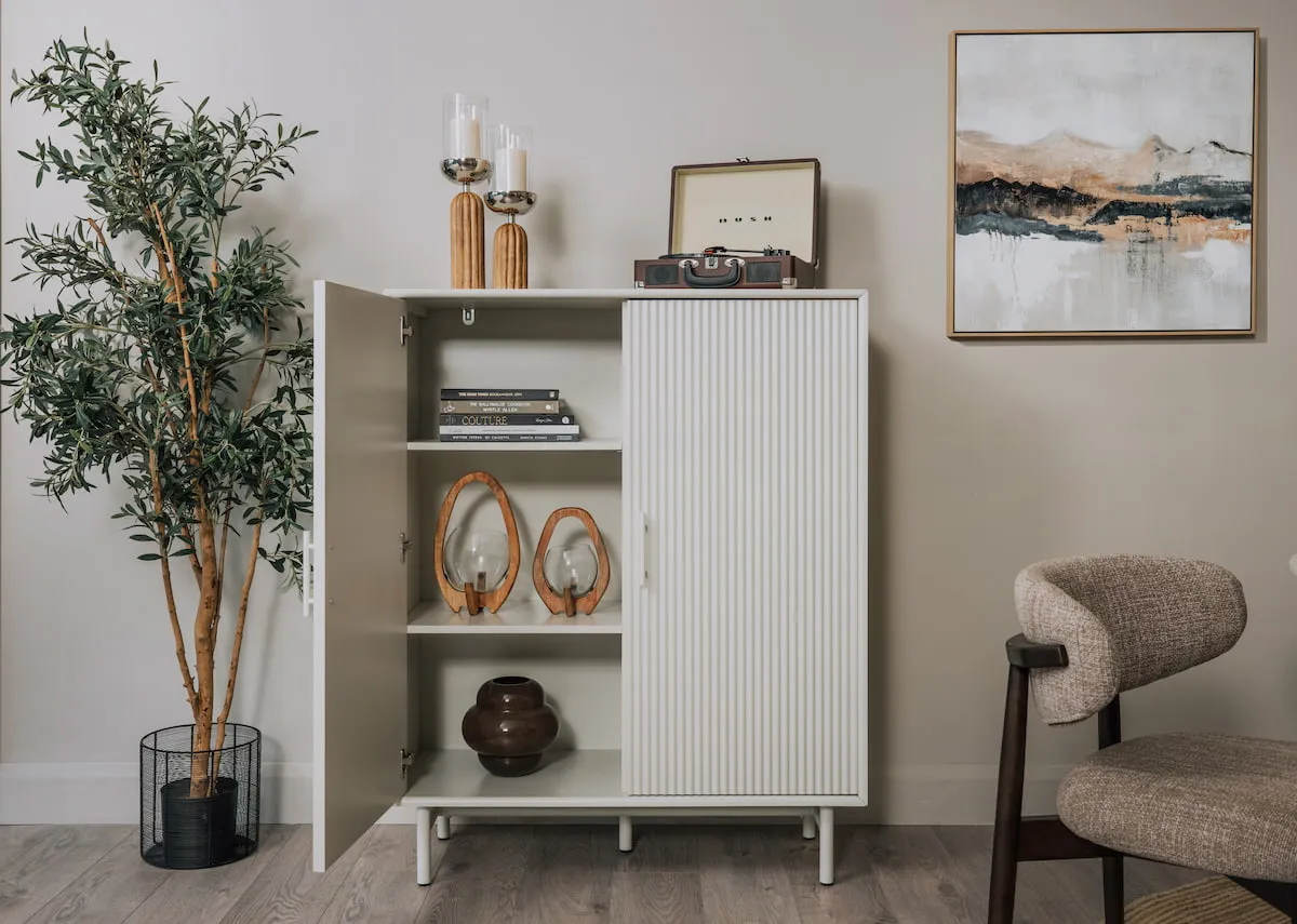 A lifestyle image of the Palma Cabinet with 1 open door to show 3 shelves of storage with Misty canvas
