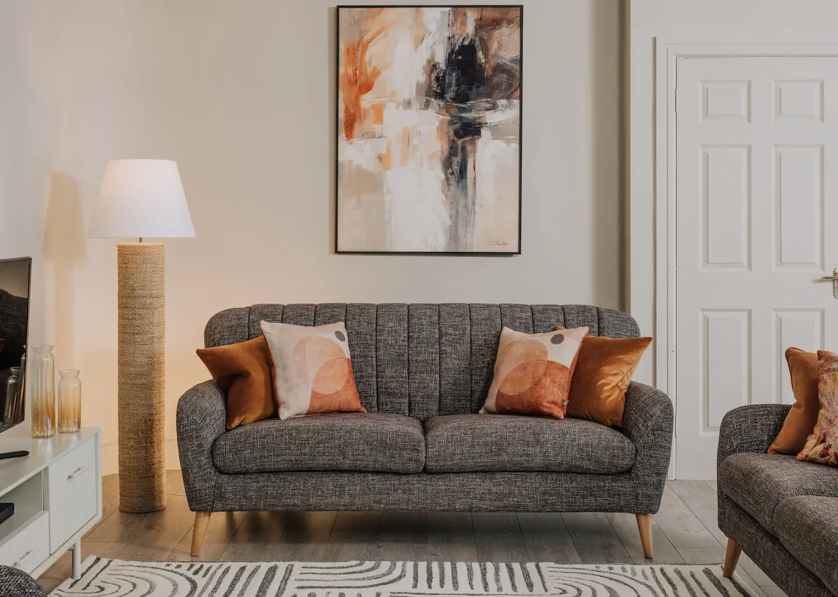 A lifestyle image of the Harper sofa with Evocative canvas and Melody floor lamp.
