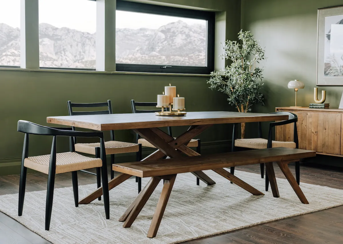 A lifestyle image of the Albion dining table bench and dining chairs with sideboard against green painted room.