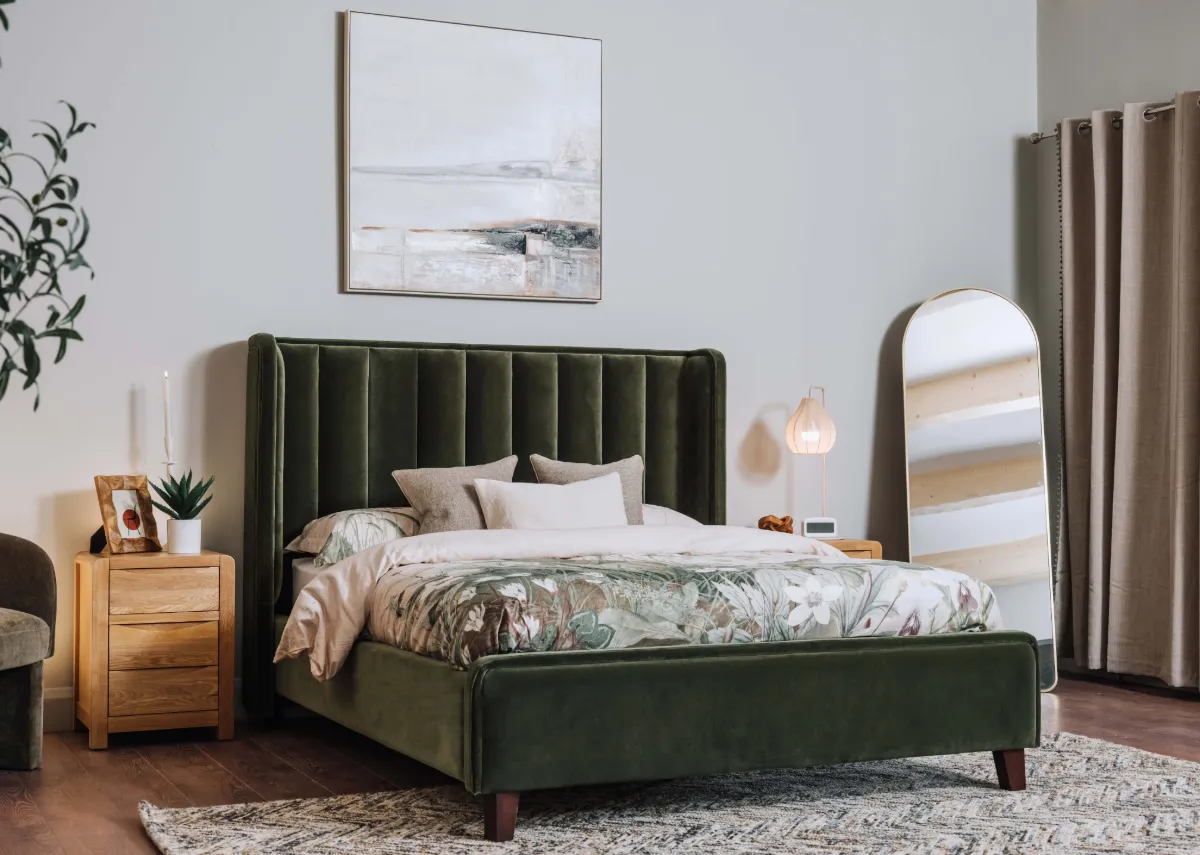 A lifestyle image of the Lowe green bedframe with the iris locker and Taina mirror on the san jose rug