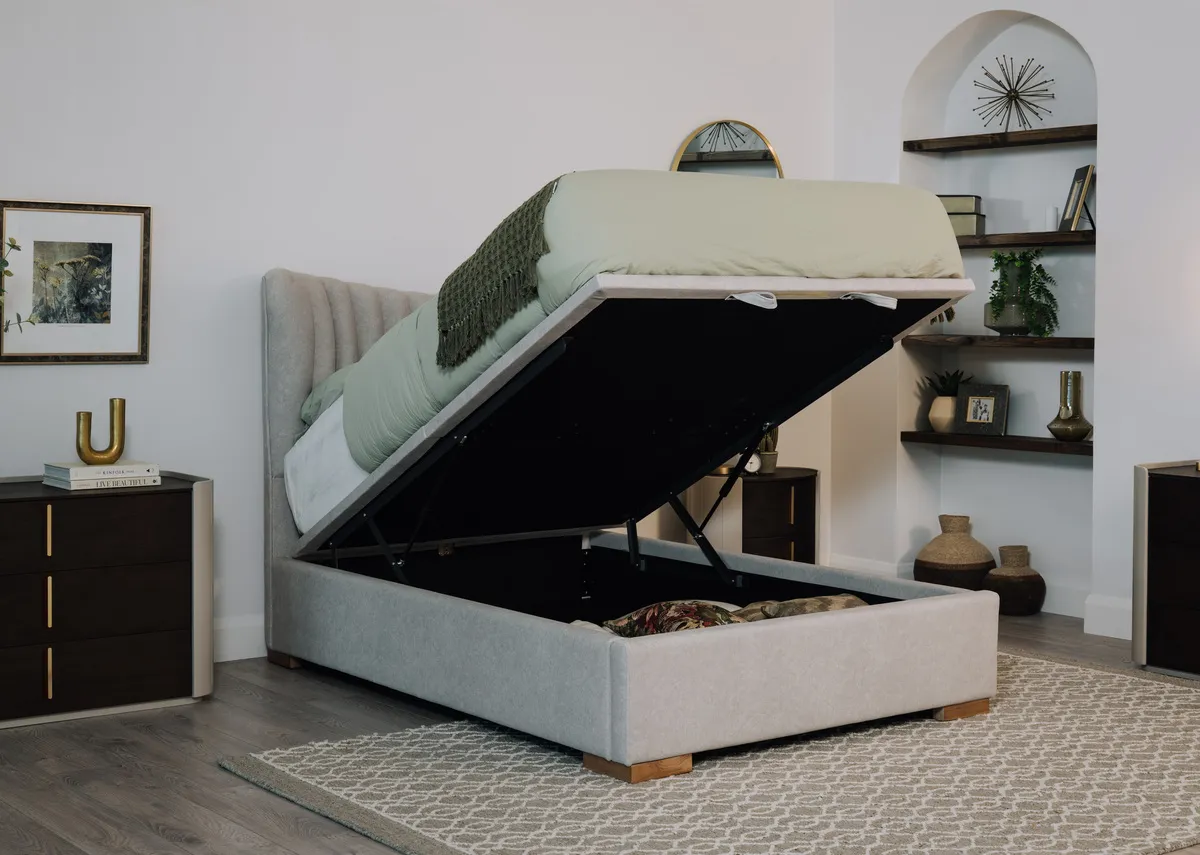 A lifestyle image of the Robin ottoman bed open showing storage with Canna dresser and Heiny rug.