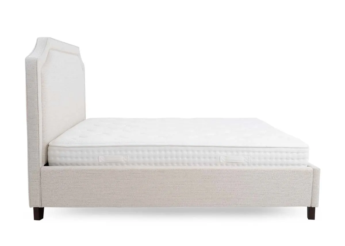 A beige fabric bed frame from EZ Livings Archie range. View of side of bed shows underneath storage.