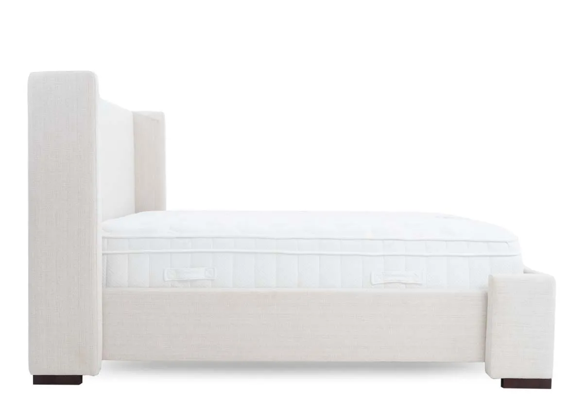A beige fabric bed frame with high winged headboard from EZ Livings Quay west range. Side view of covered frame