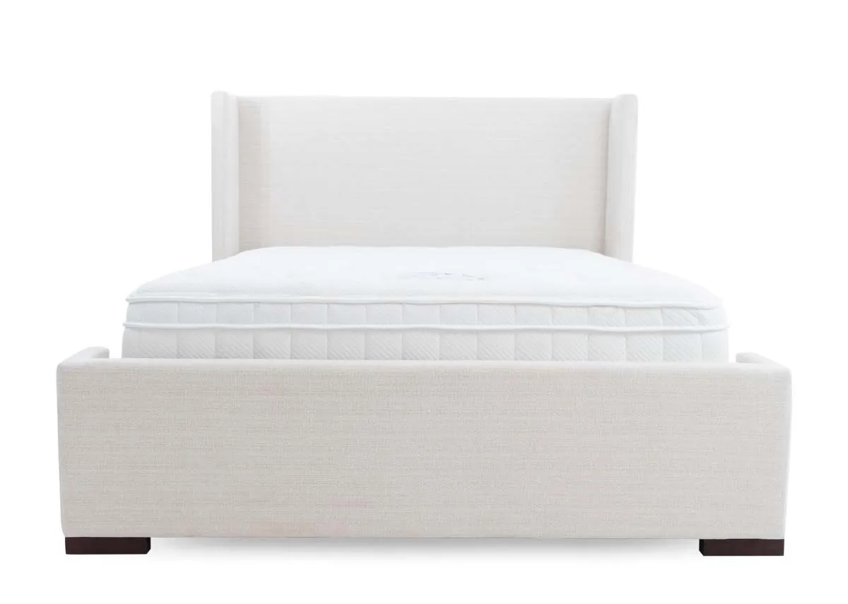 A beige fabric bed frame with high winged headboard from EZ Livings Quay west range. View from high footboard