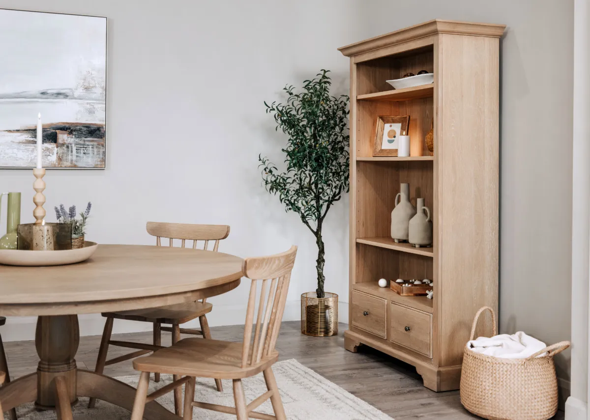 A lifestyle image of the Dawn Bookcase with round dining table and spindle chairs