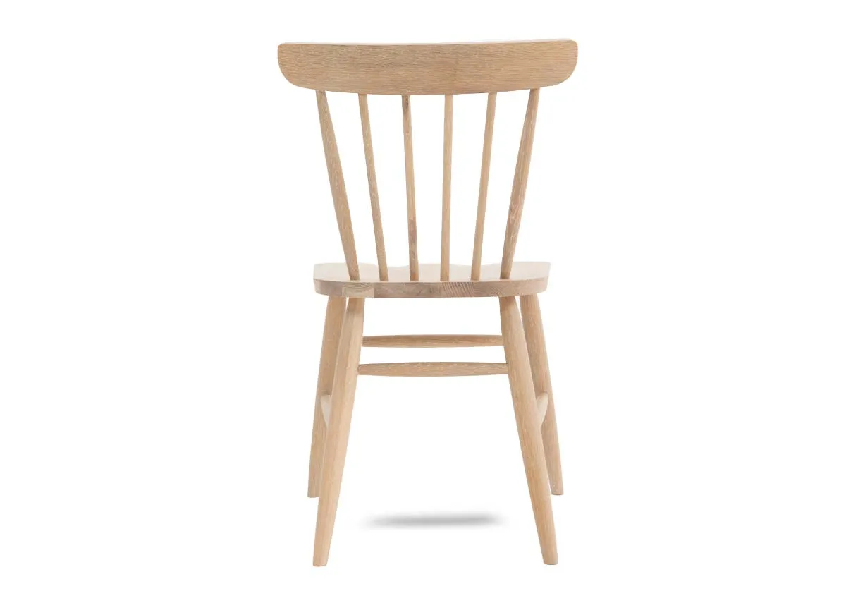 An oak dining chair with spindle curved back from EZ Living Furniture. Back view