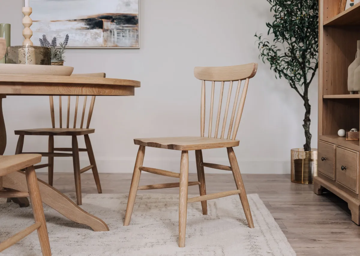 A lifestyle image of the Dawn spindle chair with dining table and bookcase