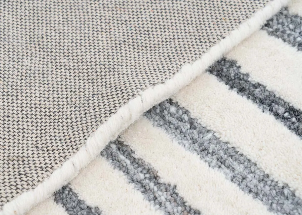A grey ivory geometric design rug from EZ Livings Orlando range. Closeup of short pile and underlay