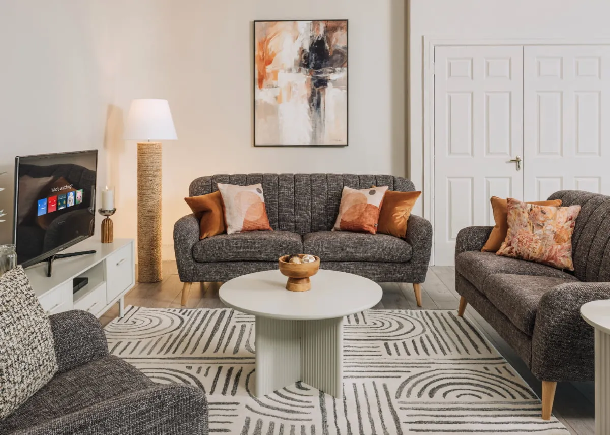 A lifestyle image of the Orlando rug with the Harper sofa set and palma tabales