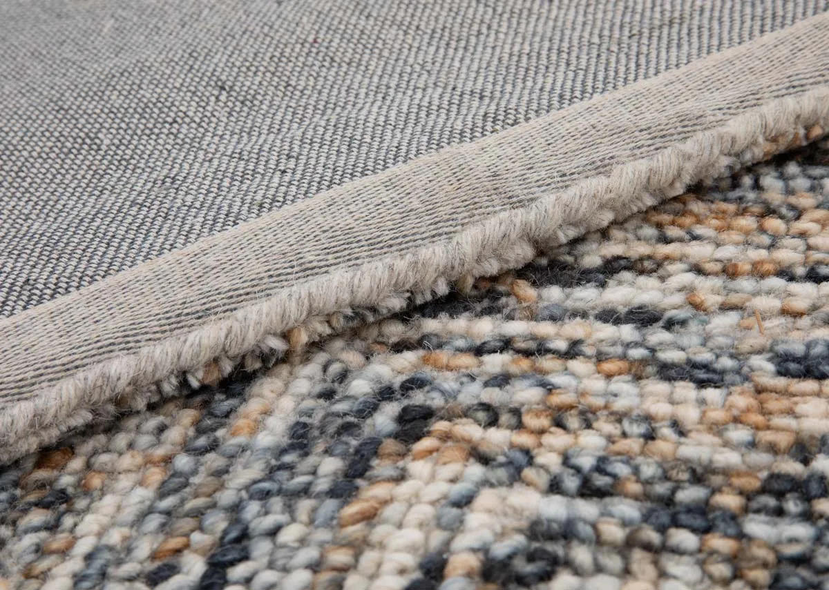 A small cream gold and grey textured rug from EZ Livings San Jose range.Closeup of underlay shows short pile