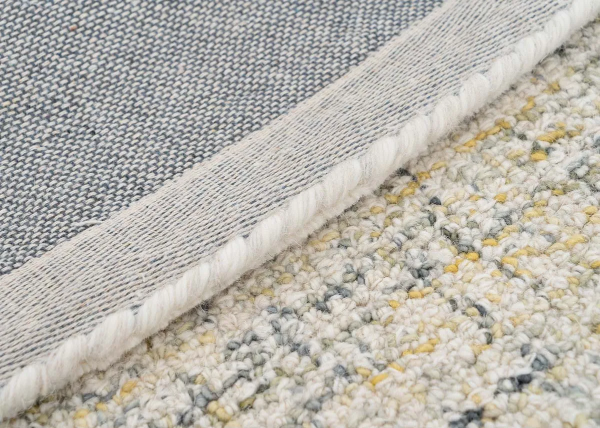 A round natural rug with 3 semi circle shapes in centre from EZ Livings Louisville range. Closeup of lemon and grey threads