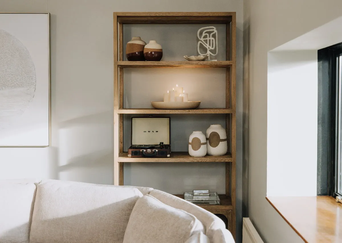 A lifestyle image of the Nova bookcase with a selection of accessories including the Danai vase in small and large