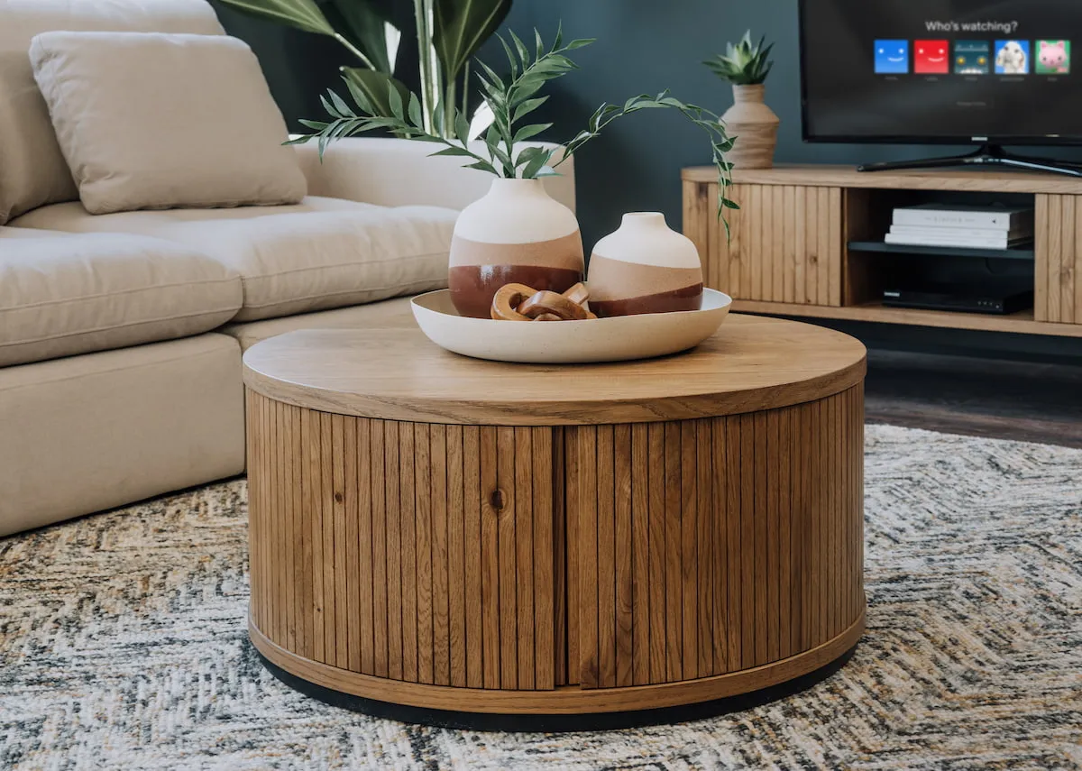 A lifestyle image of the Vega round coffee table with tray with Yuma vases.